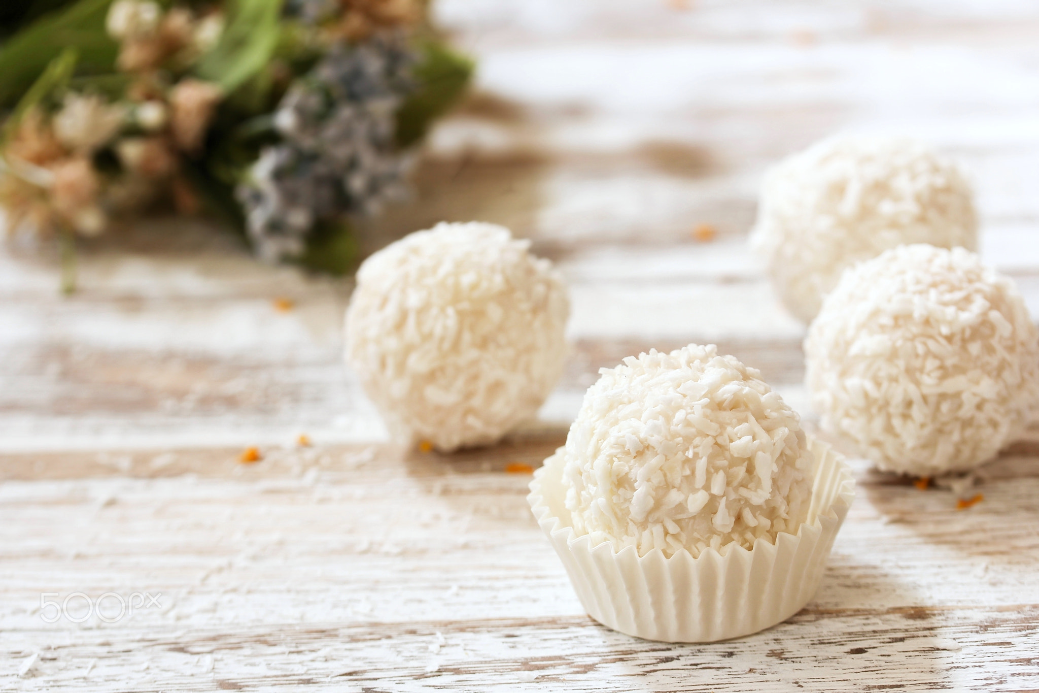 White Chocolate Coconut Truffles with spring flowers in background, selective focus