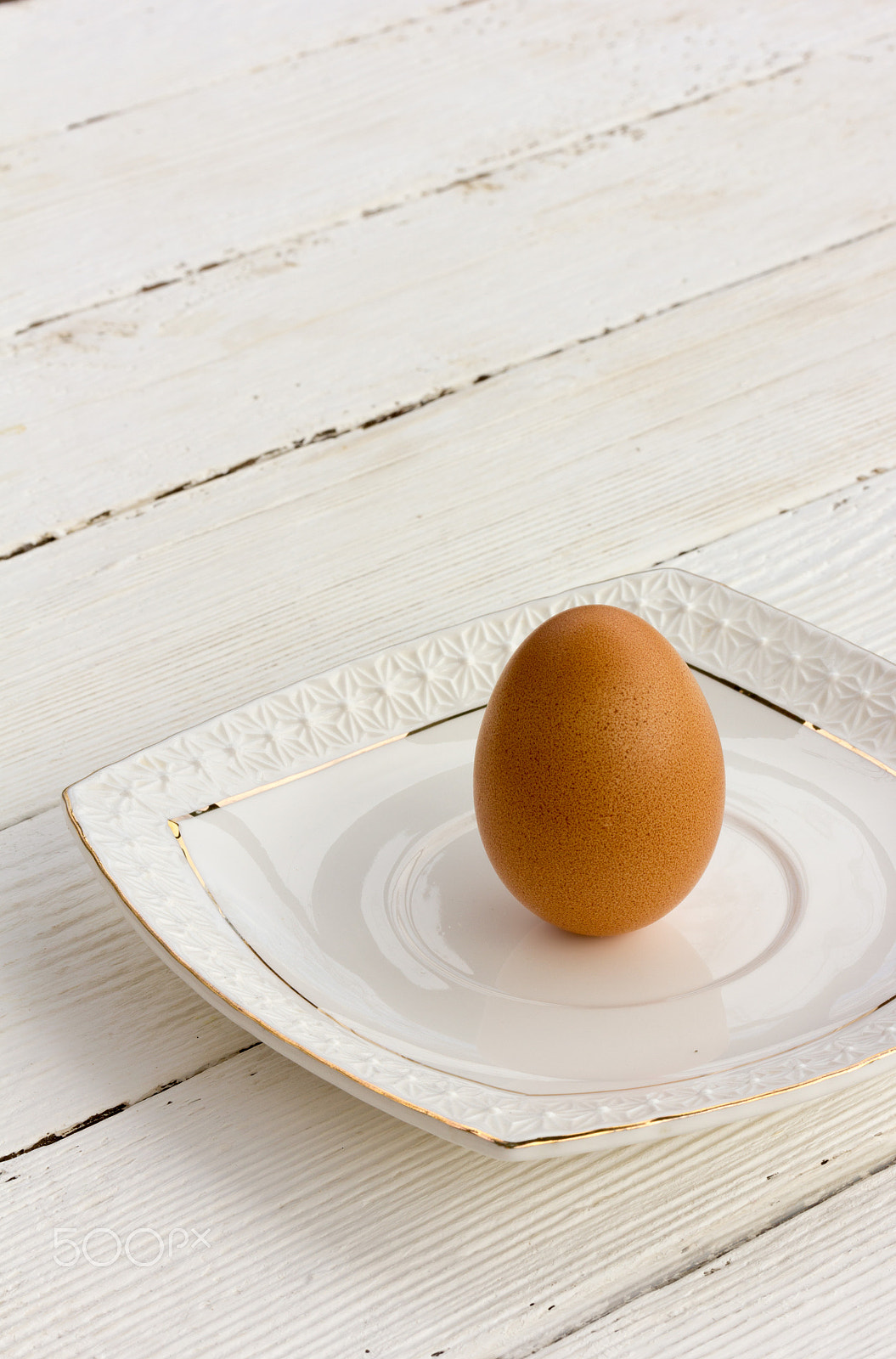 Canon EF-S 60mm F2.8 Macro USM sample photo. Brown chicken egg in the shell on a white ceramic saucer. selective focus. copy space. free space... photography