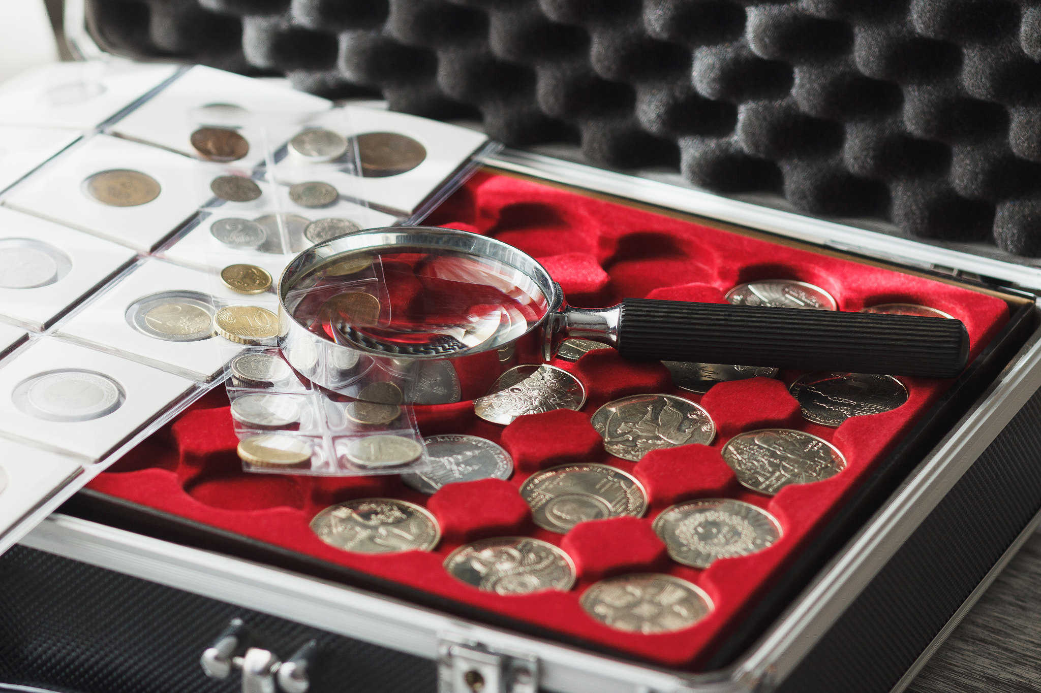 Canon EOS 600D (Rebel EOS T3i / EOS Kiss X5) + Canon EF 85mm F1.8 USM sample photo. Different collector's coins in the box with a magnifying glass photography