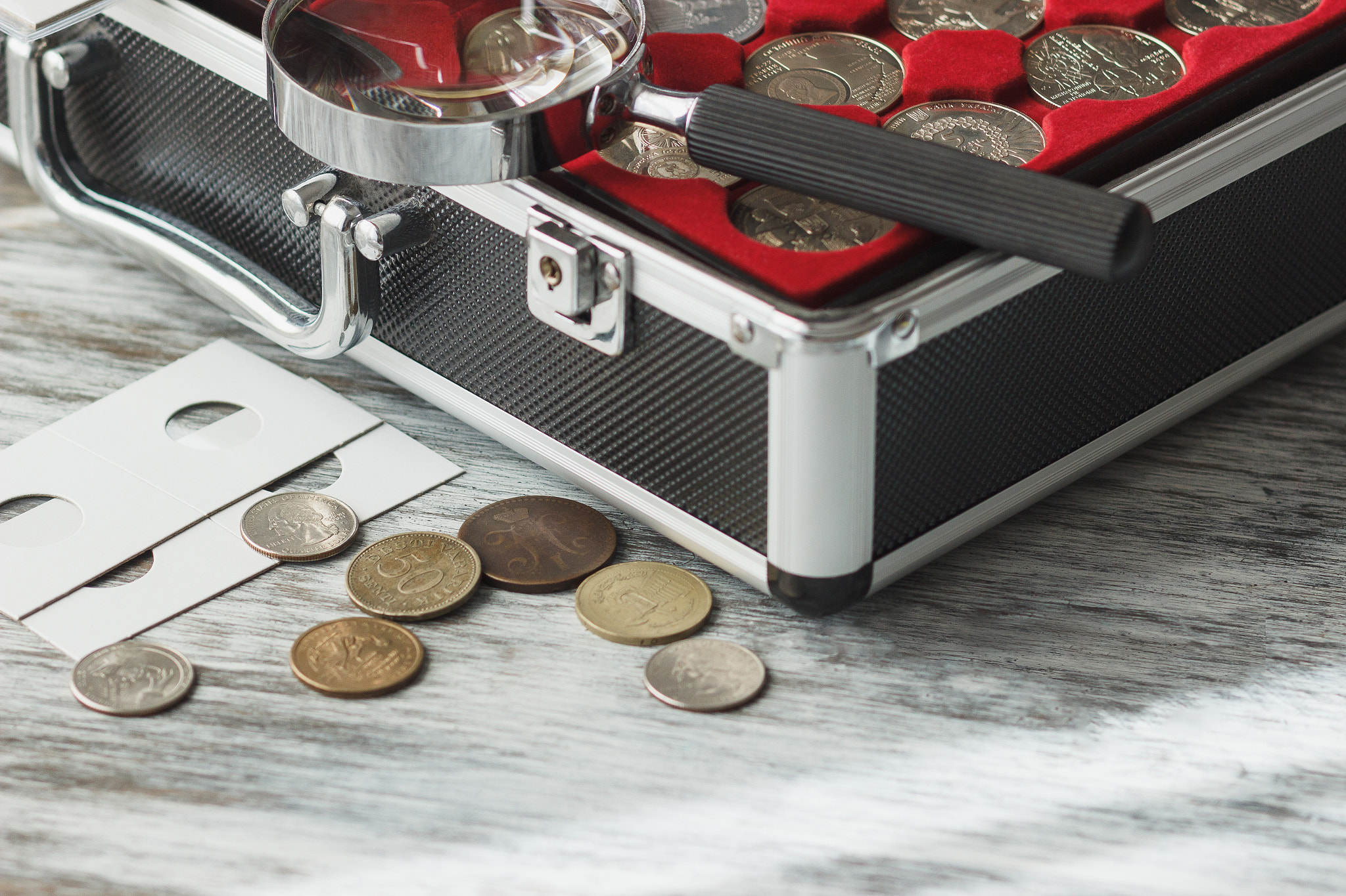 Canon EOS 600D (Rebel EOS T3i / EOS Kiss X5) + Canon EF 85mm F1.8 USM sample photo. Different collector's coins in the box with a magnifying glass photography