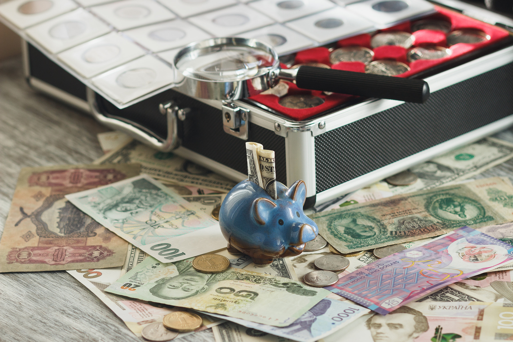 Canon EOS 600D (Rebel EOS T3i / EOS Kiss X5) + Canon EF 85mm F1.8 USM sample photo. Coins and banknotes in the box, with a magnifying glass and piggy bank photography