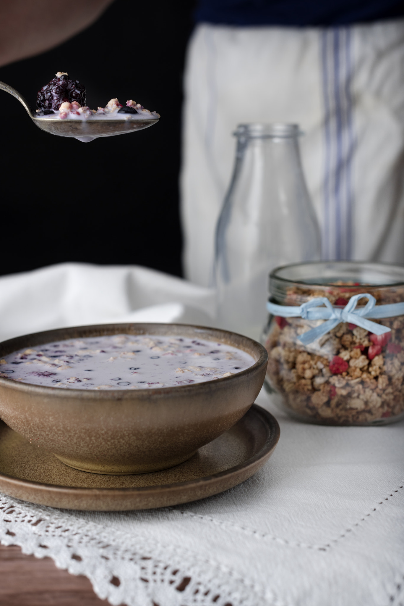 Nikon D810 sample photo. Bite milky soup. muesli with milk in brown bowl. photography