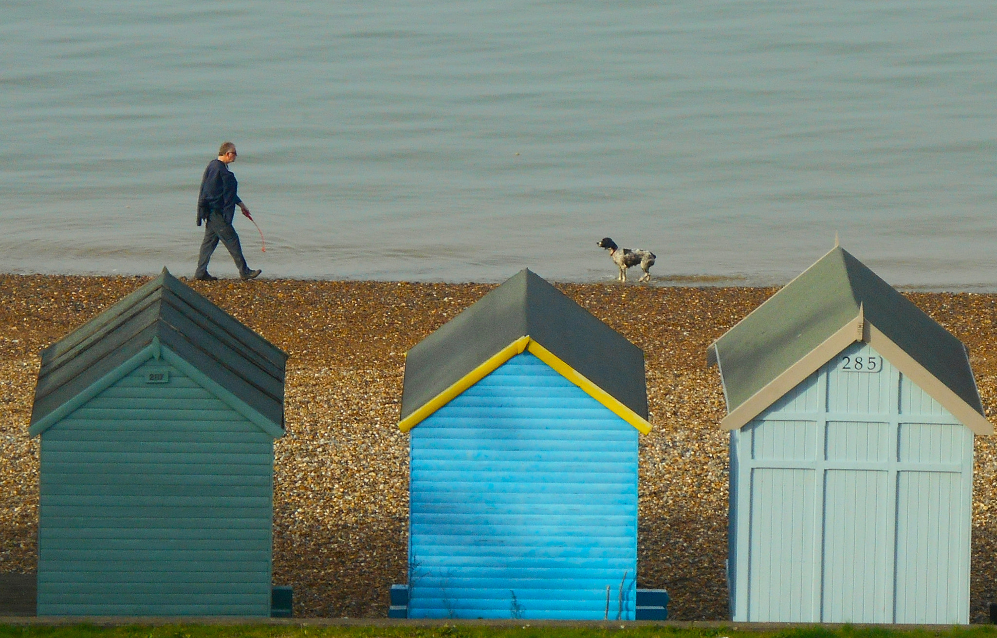 Nikon COOLPIX S3400 sample photo. Man and dog and beach huts photography