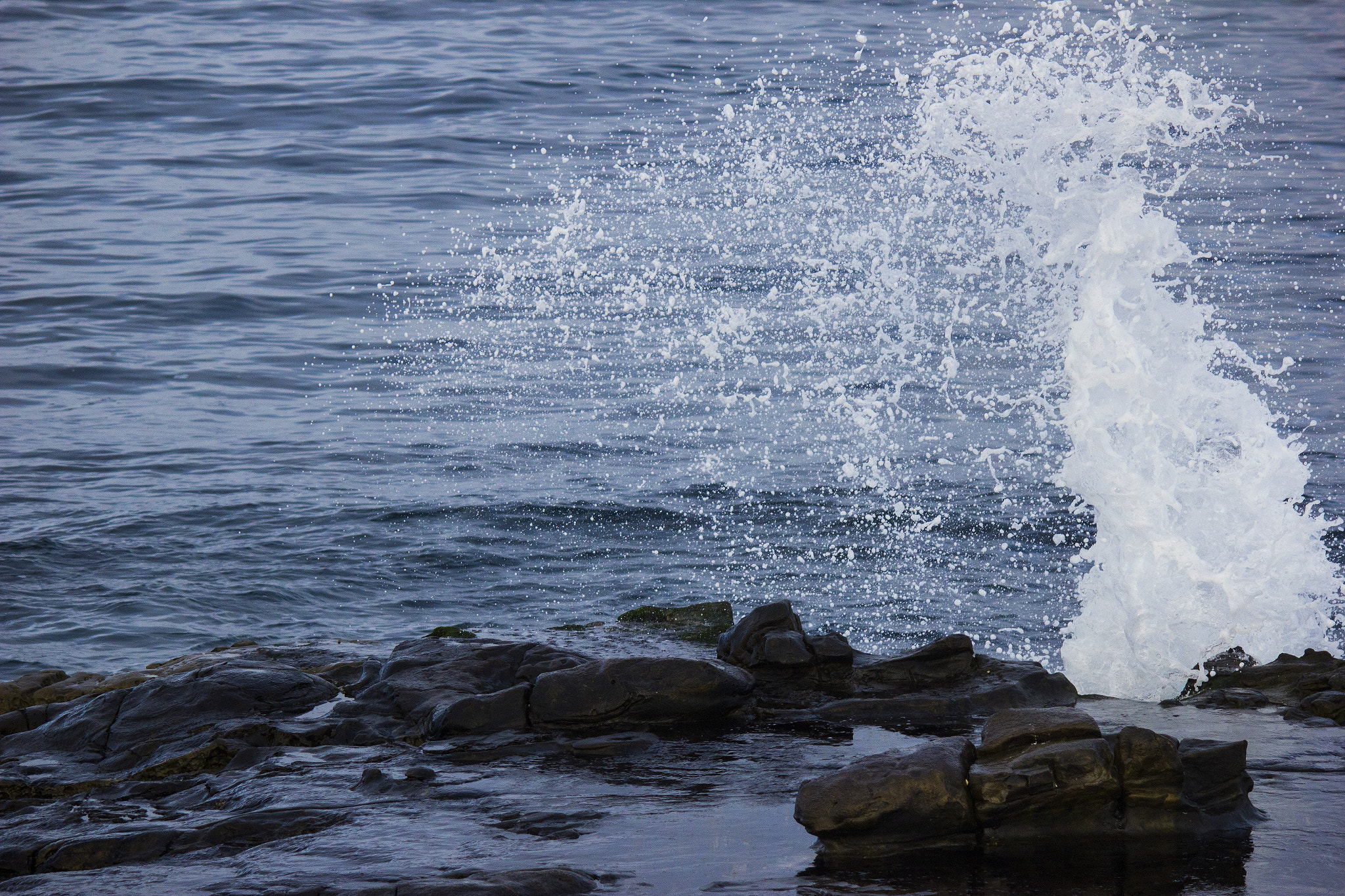 Canon EF-S 55-250mm F4-5.6 IS sample photo. Ocean waves crashing against rocks making spray photography