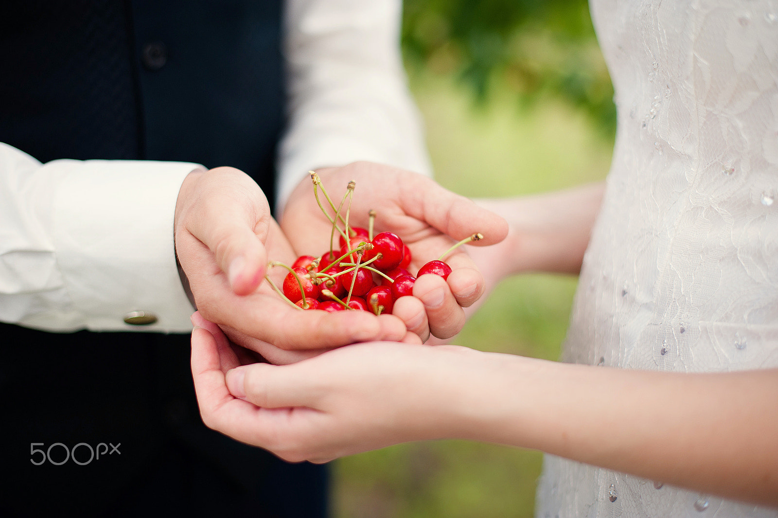 Nikon D700 + Nikon AF-S Nikkor 50mm F1.4G sample photo. Bride and groom holding cherry berries photography