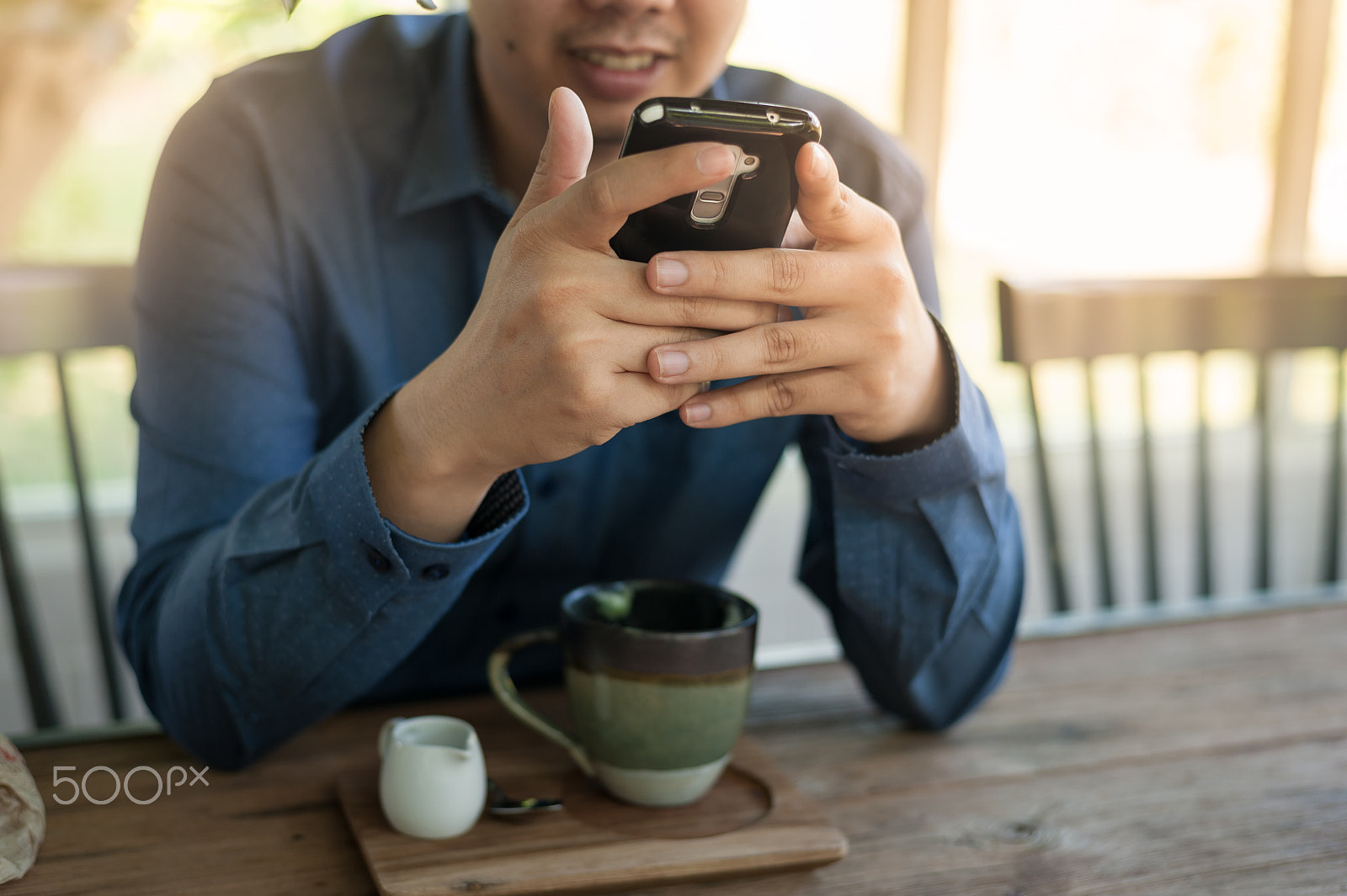Nikon D700 + Nikon AF-S Nikkor 50mm F1.8G sample photo. Businessman using mobile phone while sitting in coffee shop photography