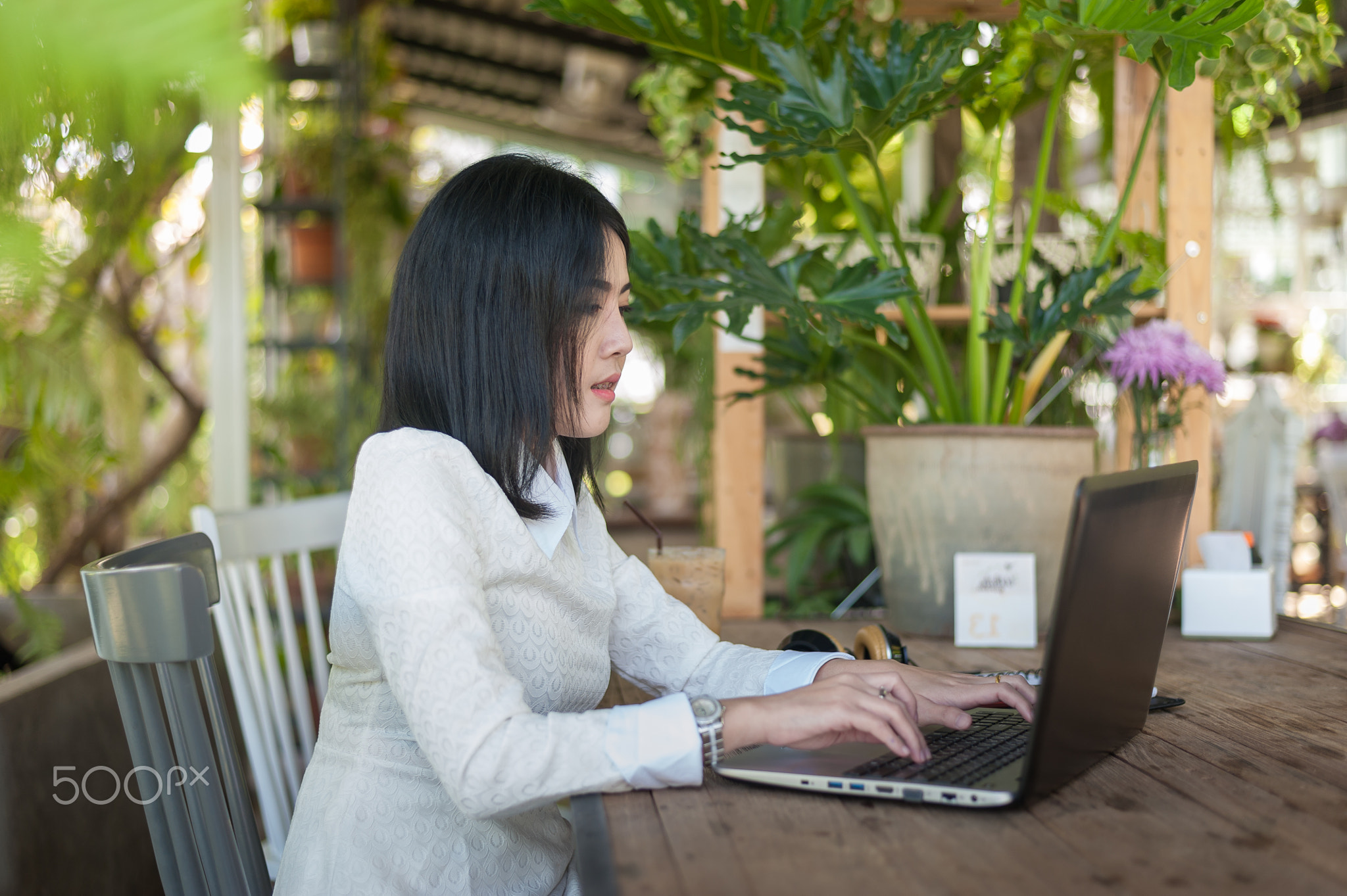 Young Asian woman working with laptop in coffee shop