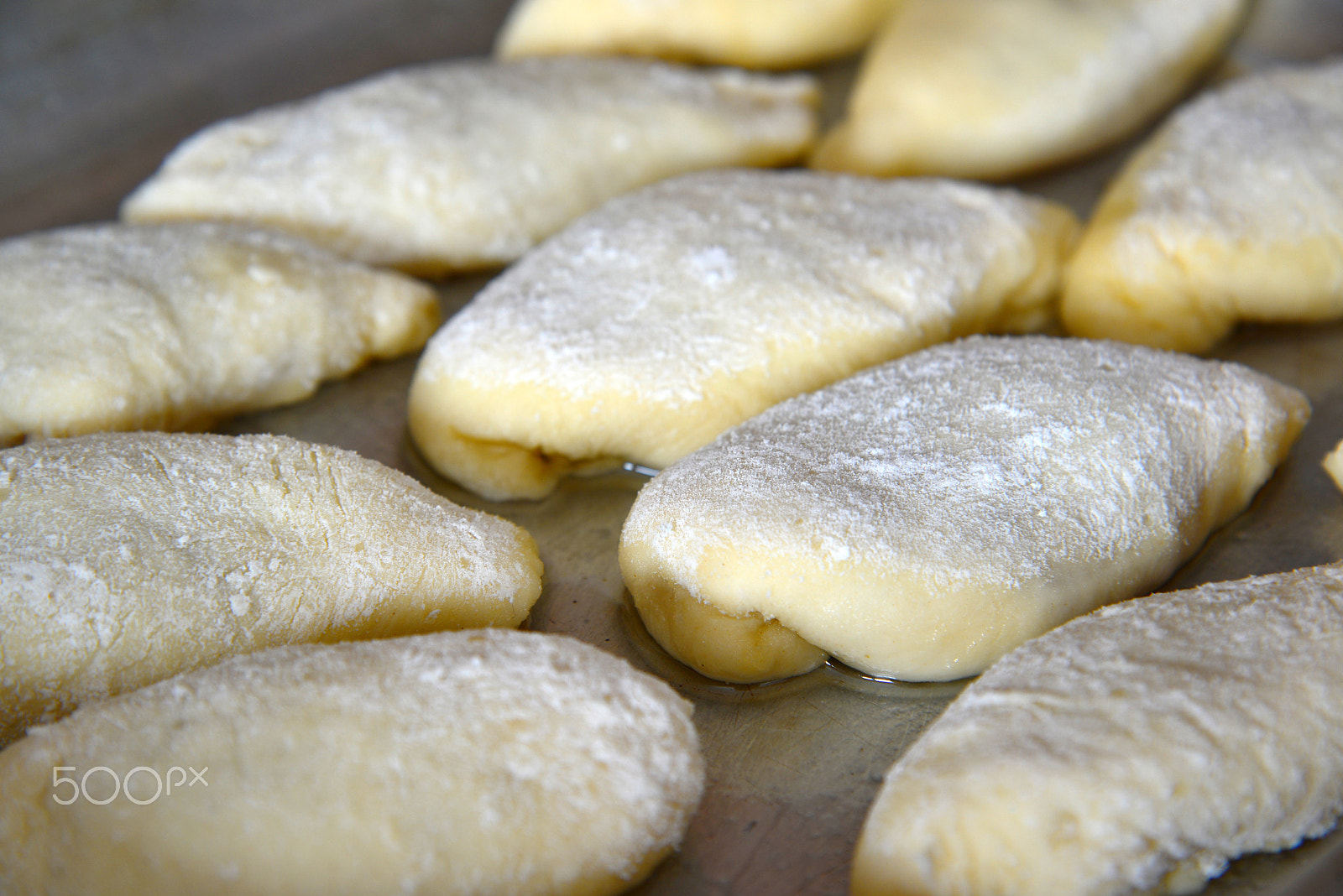 Nikon AF-S Nikkor 24-120mm F4G ED VR sample photo. Lots of pies on baking sheet of raw dough photography