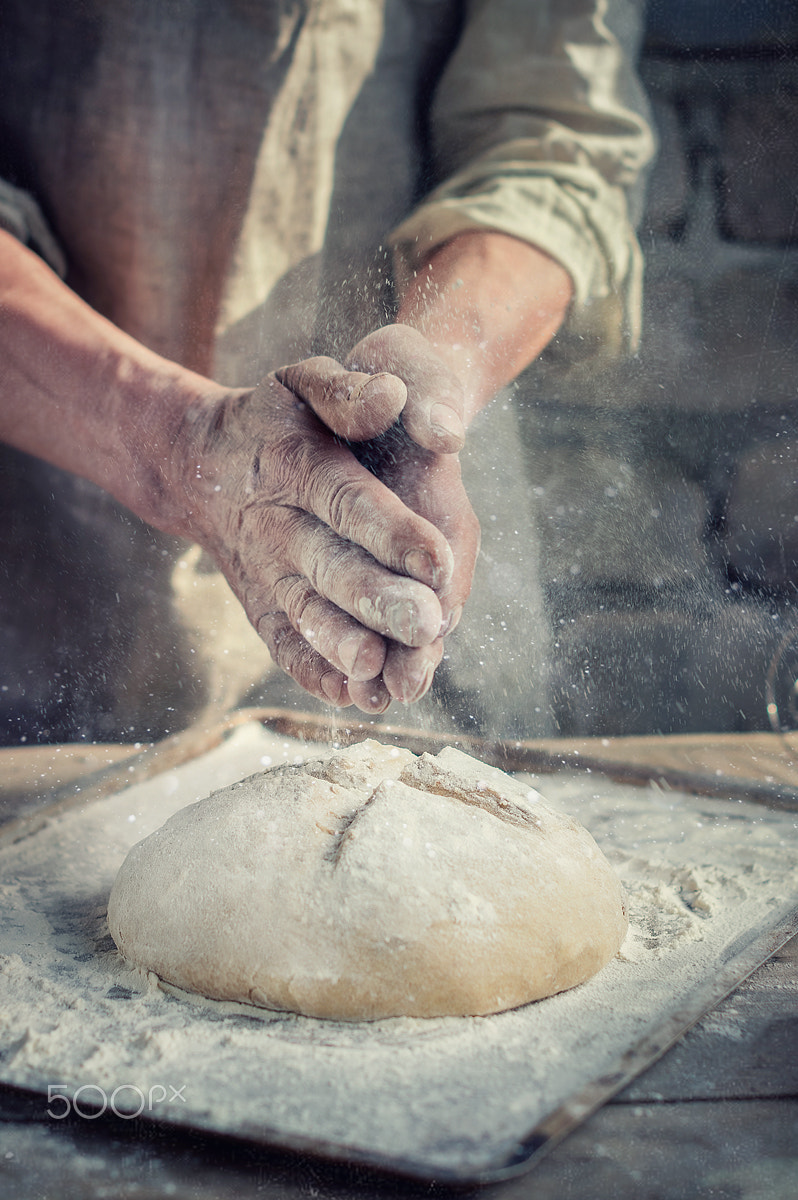 Nikon D3200 + Nikon AF-S Nikkor 50mm F1.4G sample photo. Bread in baker's hand photography