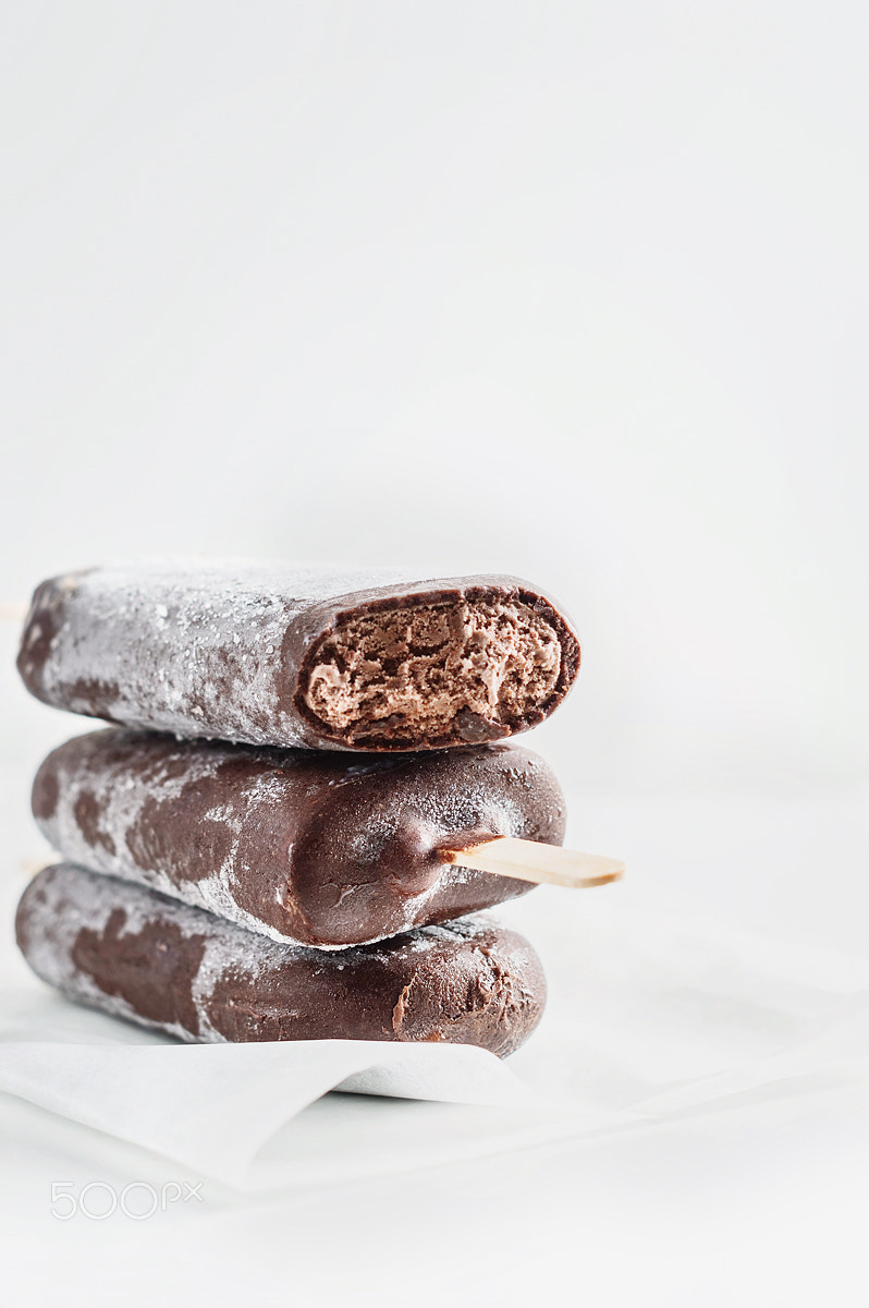 Nikon D3200 + Nikon AF-S Nikkor 50mm F1.4G sample photo. Chocolate ice cream on a stick on a white background photography