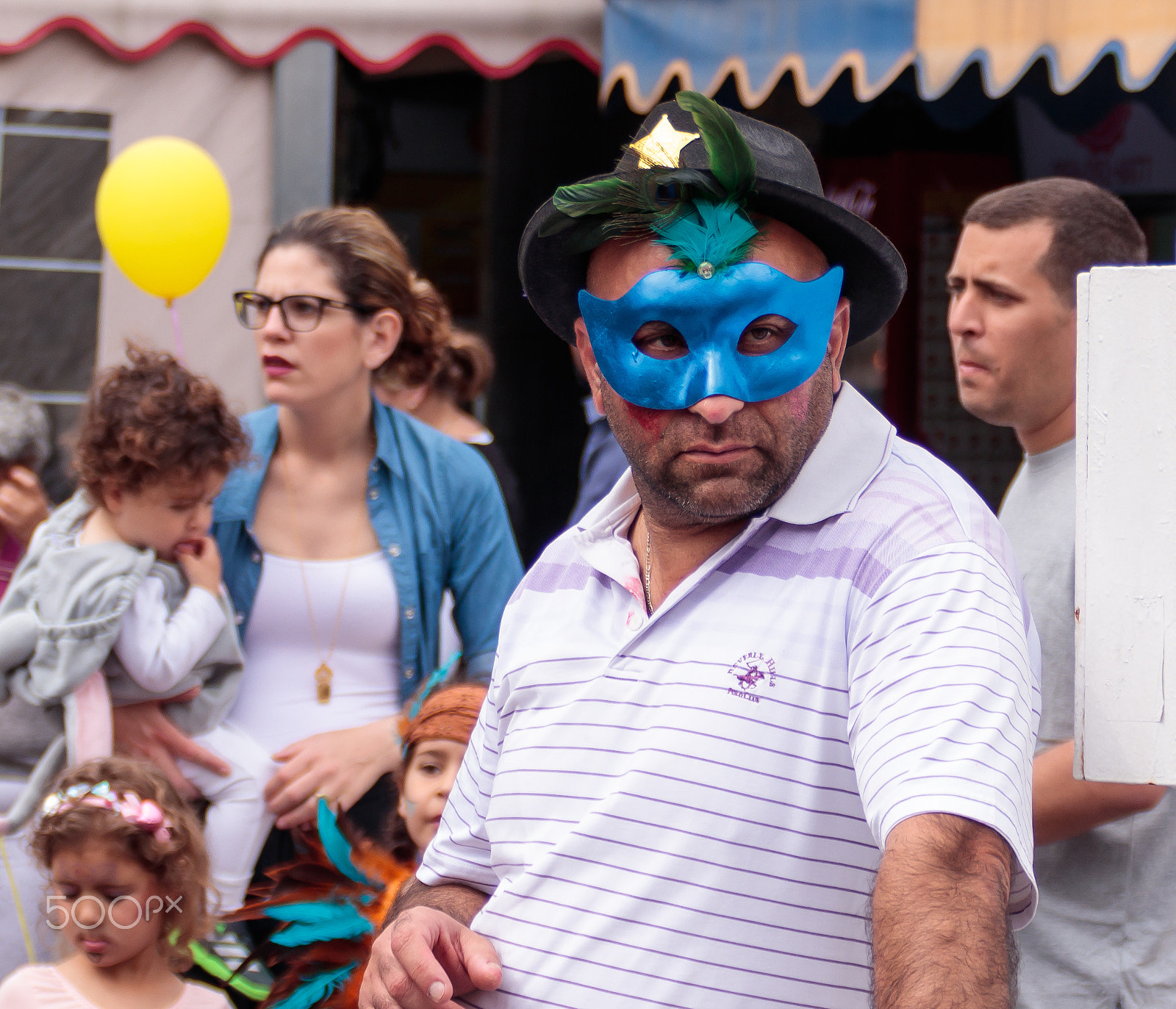 Canon EF 75-300mm F4.0-5.6 IS USM sample photo. Man in blue mask stands and looks at carnival parade photography