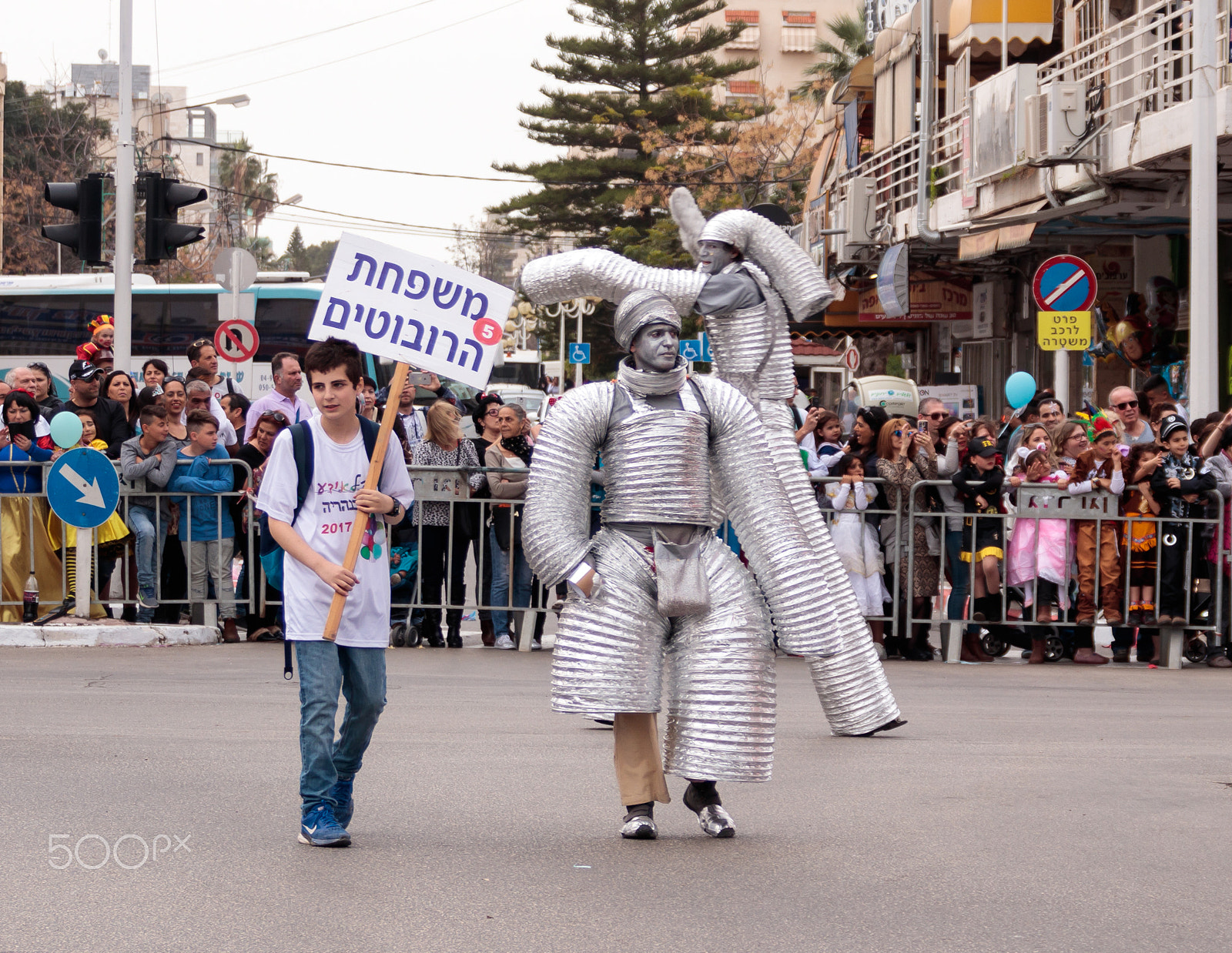 Canon EOS 80D + Canon EF 75-300mm F4.0-5.6 IS USM sample photo. Participants at carnival dressed in robots are walking along str photography