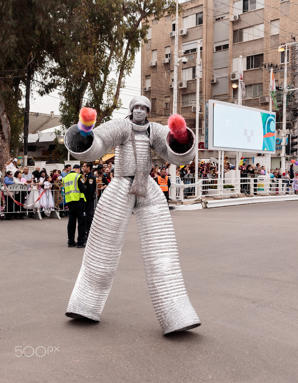 Canon EOS 80D + Canon EF 75-300mm F4.0-5.6 IS USM sample photo. Participants at carnival dressed in robots are walking along str photography