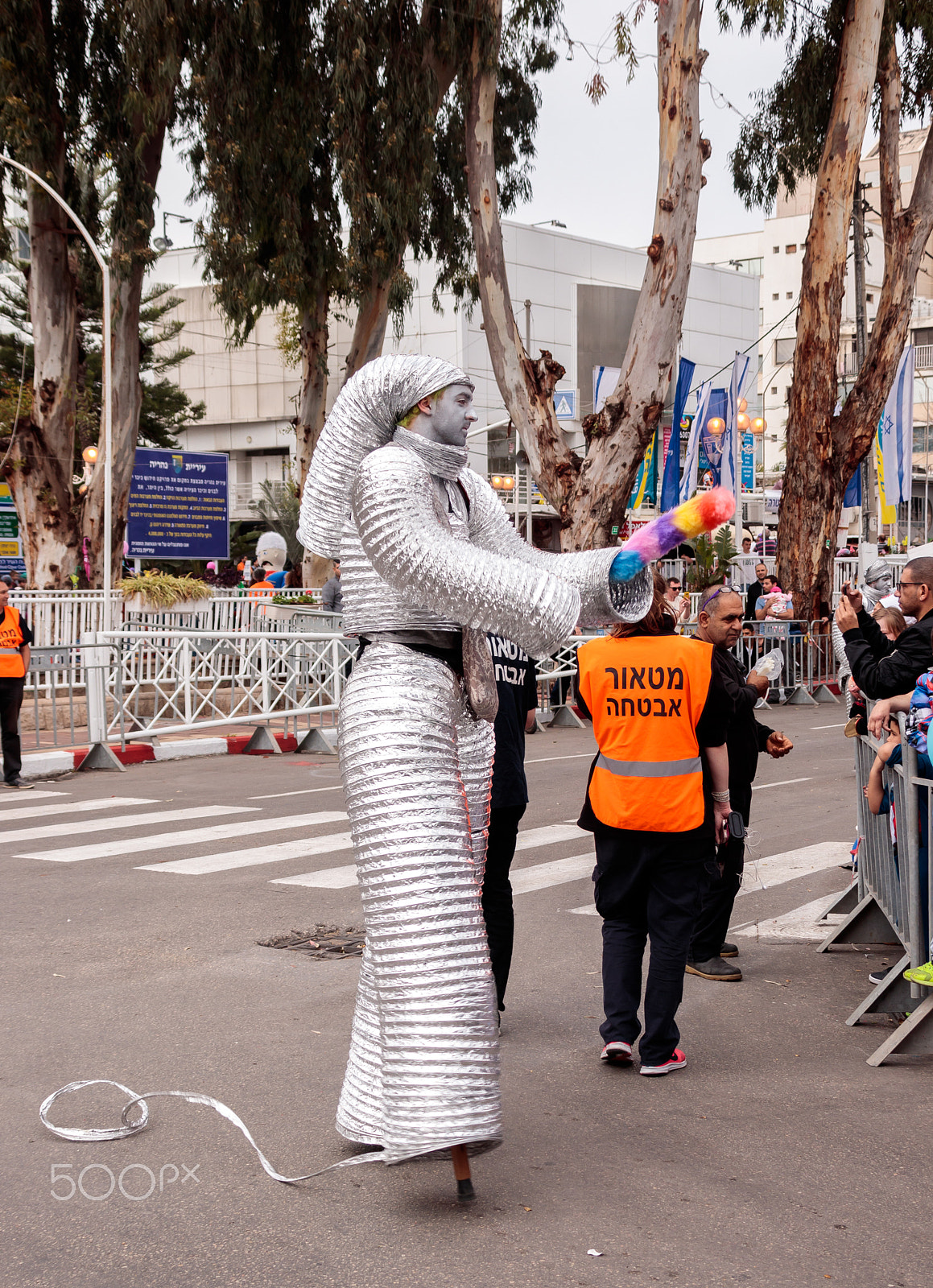 Canon EOS 80D + Canon EF 75-300mm F4.0-5.6 IS USM sample photo. Participants at carnival dressed in robots are walking along str photography