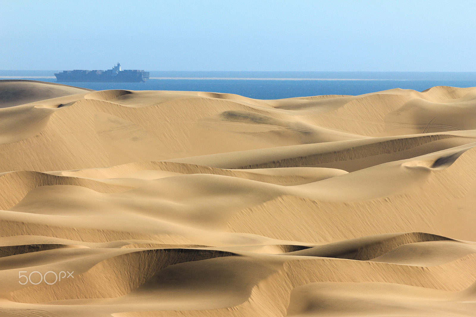 Canon EOS 550D (EOS Rebel T2i / EOS Kiss X4) + Tamron SP 70-300mm F4-5.6 Di VC USD sample photo. Big sand dunes. ocean with ships and boat in background. photography