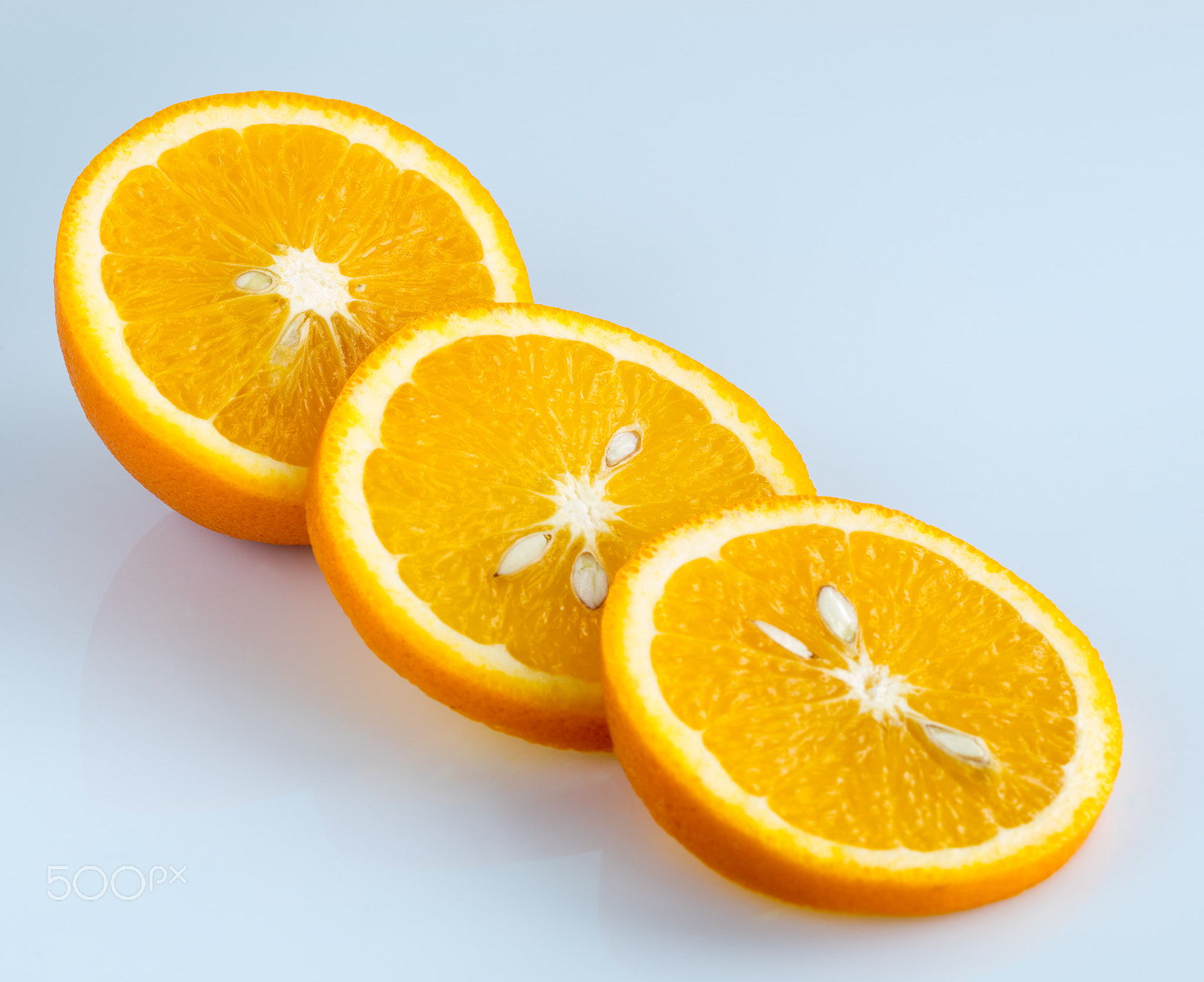 Canon EF 100mm F2.8L Macro IS USM sample photo. Sliced orange on a light blue background photography