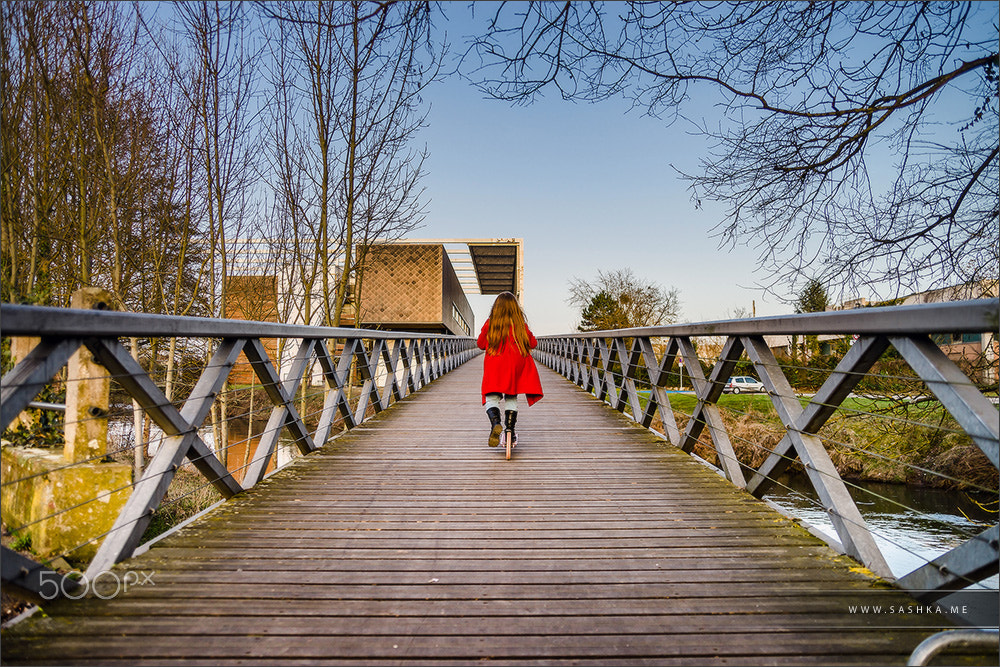 Sony a99 II + Tamron SP 24-70mm F2.8 Di VC USD sample photo. Little girl skating on the long wooden bridge over the river photography