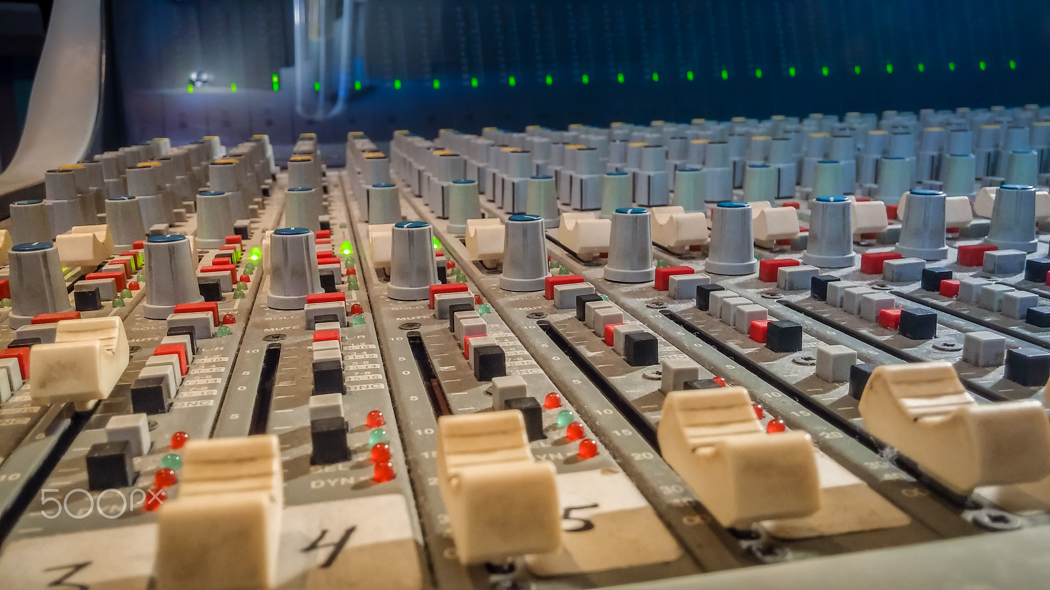 Professional audio mixing console with faders in recording studi