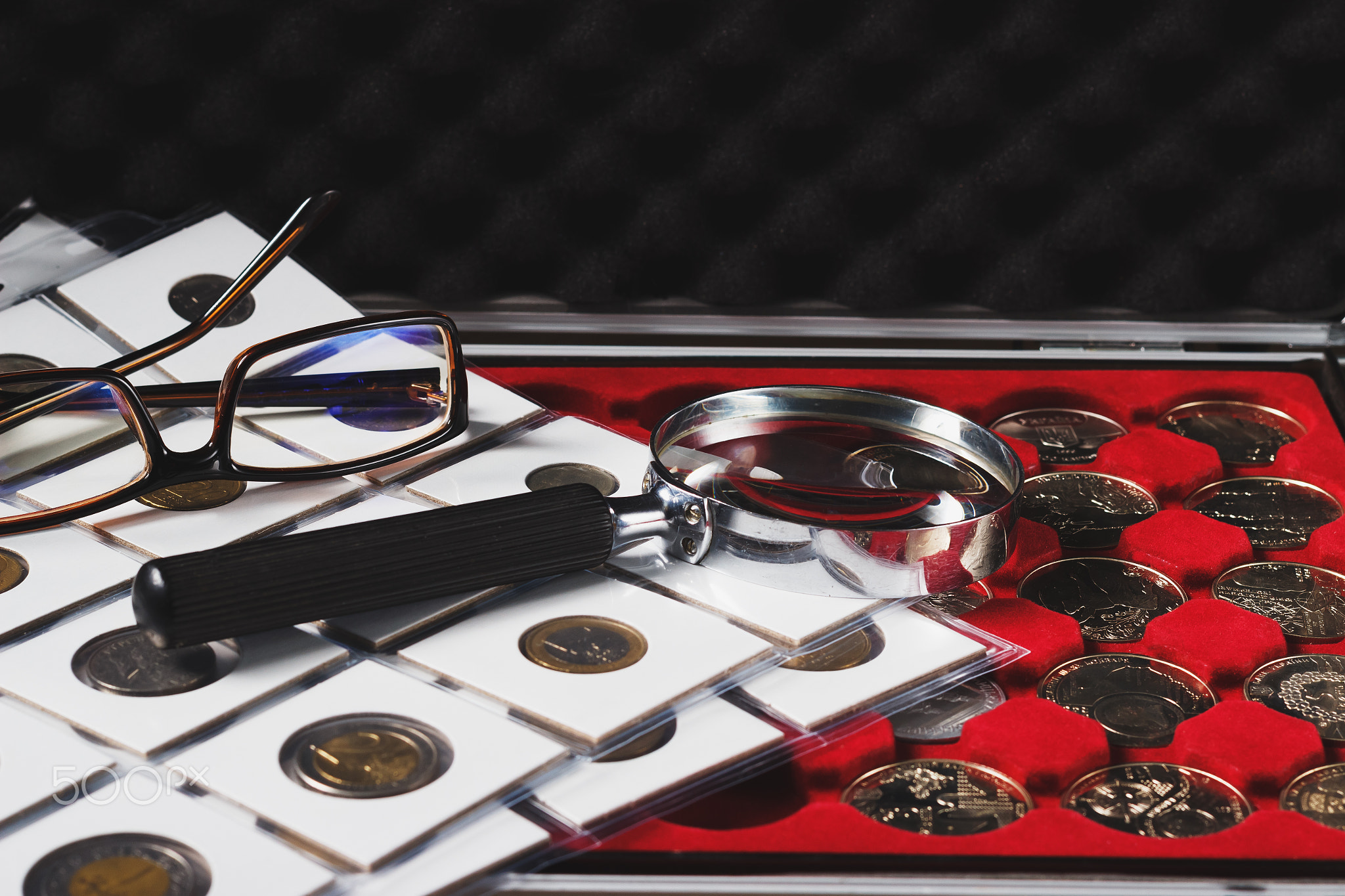 Box with collectible coins and magnifying glass