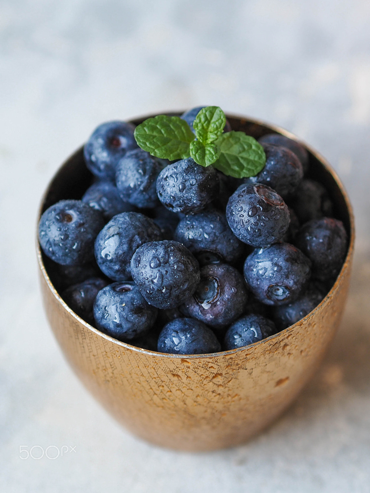 Olympus OM-D E-M10 sample photo. Ripe wet blueberries in a gold glass photography