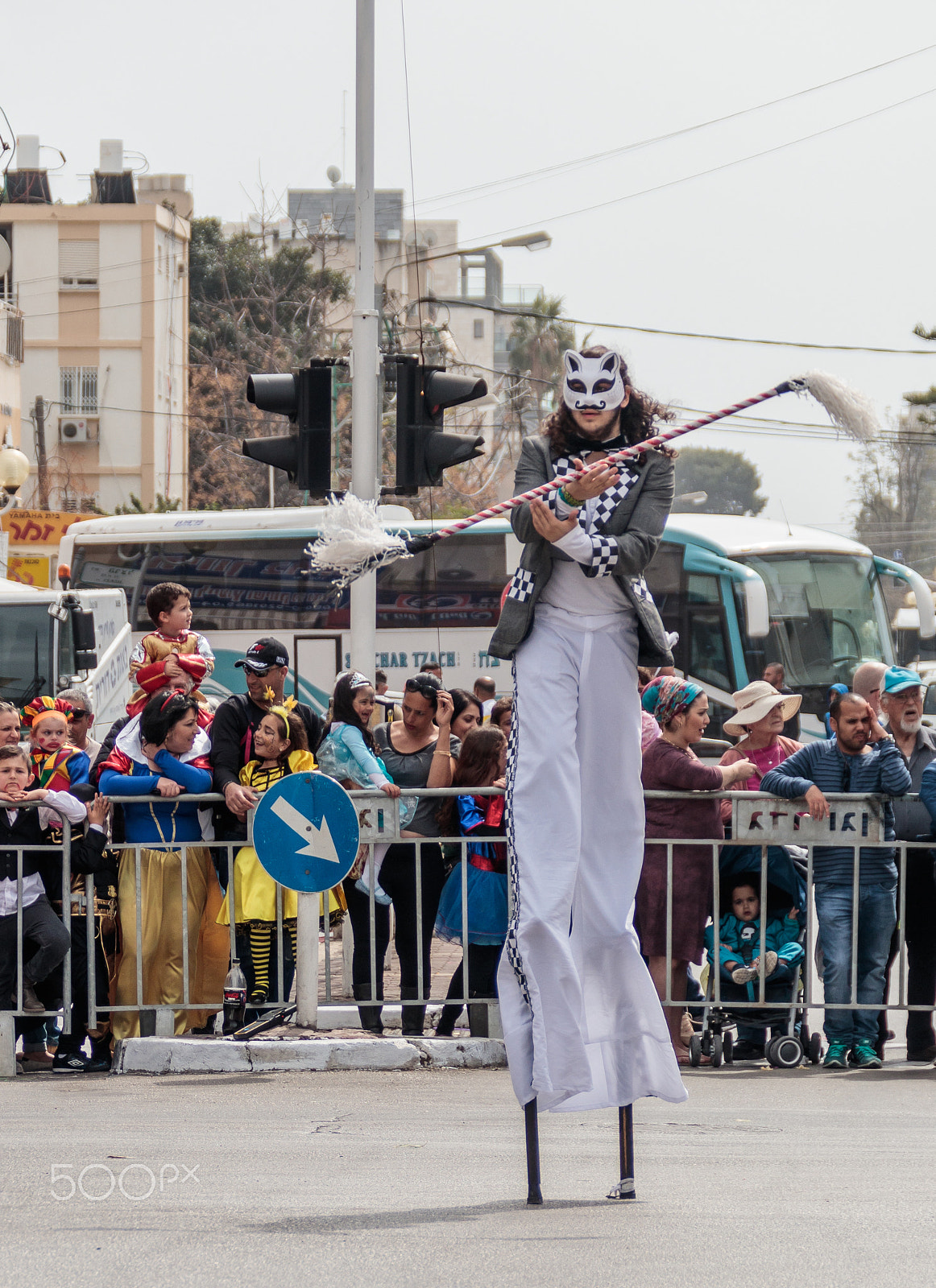 Canon EF 75-300mm F4.0-5.6 IS USM sample photo. Participants at carnival on stilts are walking along the street photography