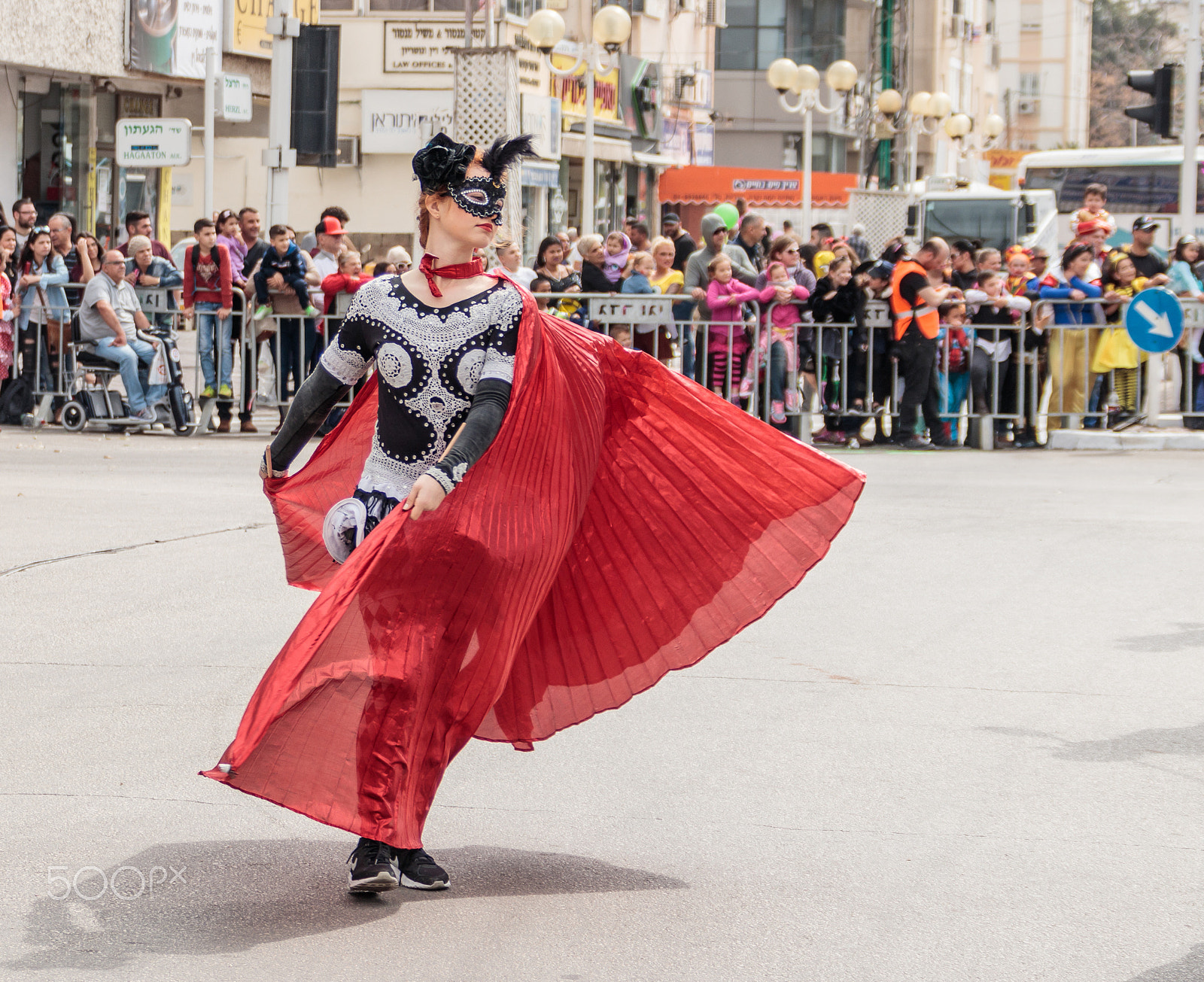 Canon EF 75-300mm F4.0-5.6 IS USM sample photo. Participant at carnival is walking along the street photography