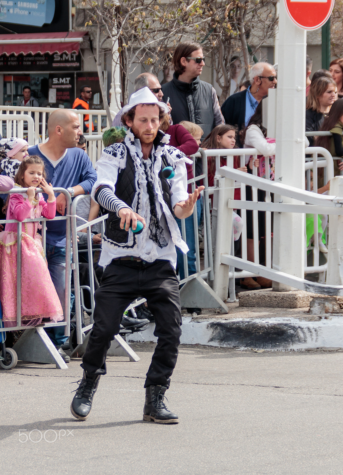 Canon EOS 80D + Canon EF 75-300mm F4.0-5.6 IS USM sample photo. Juggler with colored balls walking along the street at carnival photography