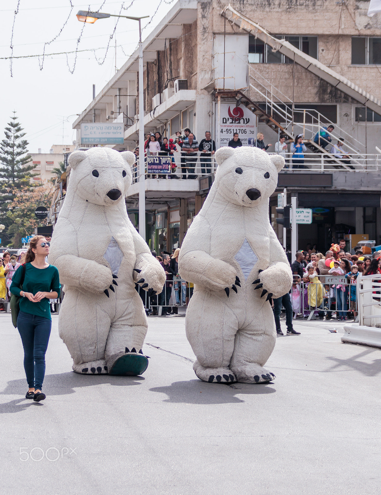 Canon EOS 80D + Canon EF 75-300mm F4.0-5.6 IS USM sample photo. Participant in carnival dressed as white bears goes near viewers photography