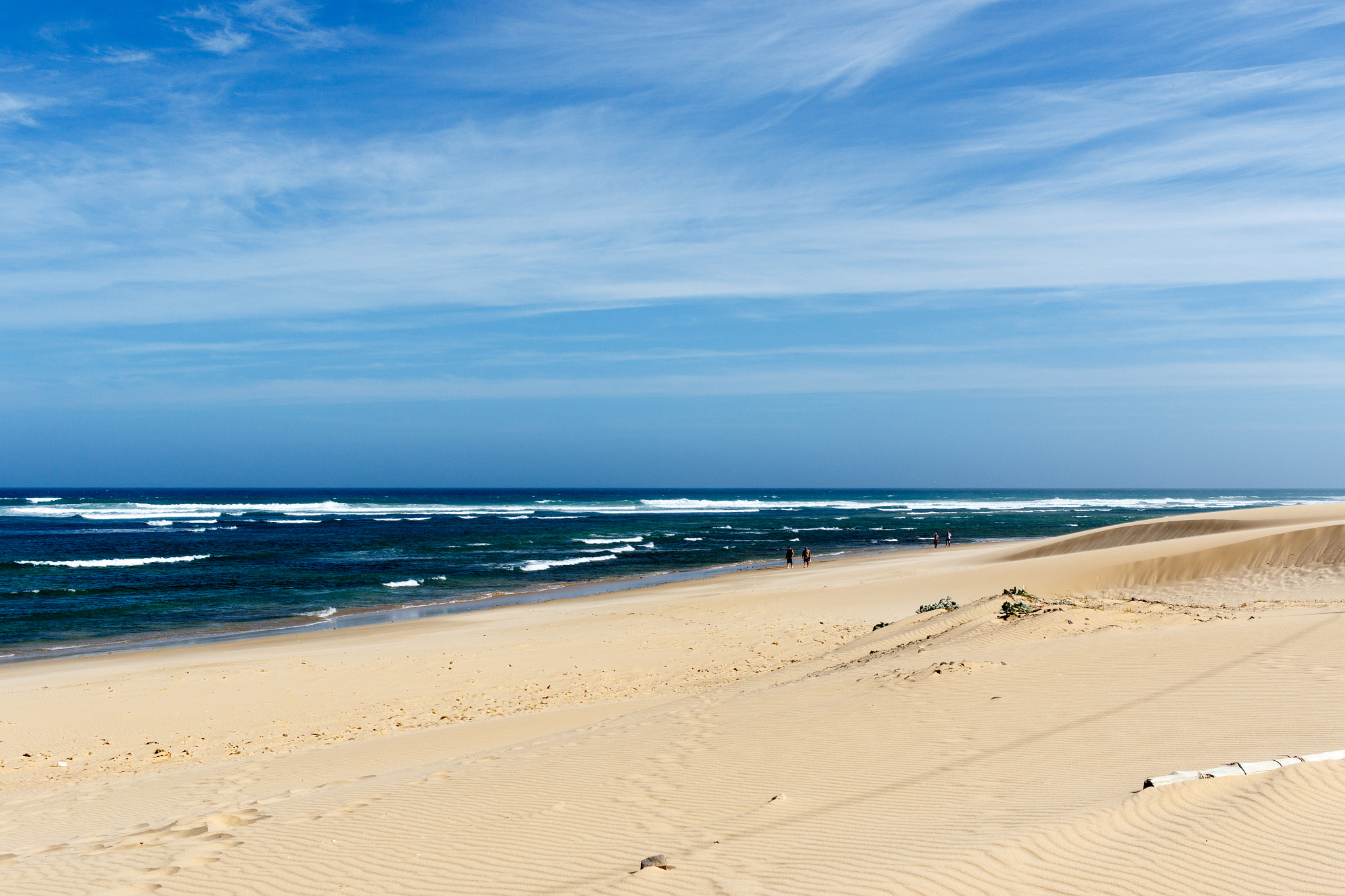 Canon EF-S 24mm F2.8 STM sample photo. Side view of the beach with people walking photography