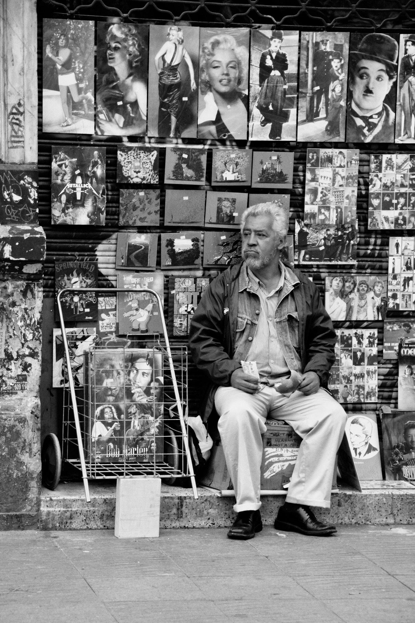 Canon EOS 1100D (EOS Rebel T3 / EOS Kiss X50) + Canon EF 75-300mm F4.0-5.6 IS USM sample photo. Old man sellin paintings in the streets of bogotá photography