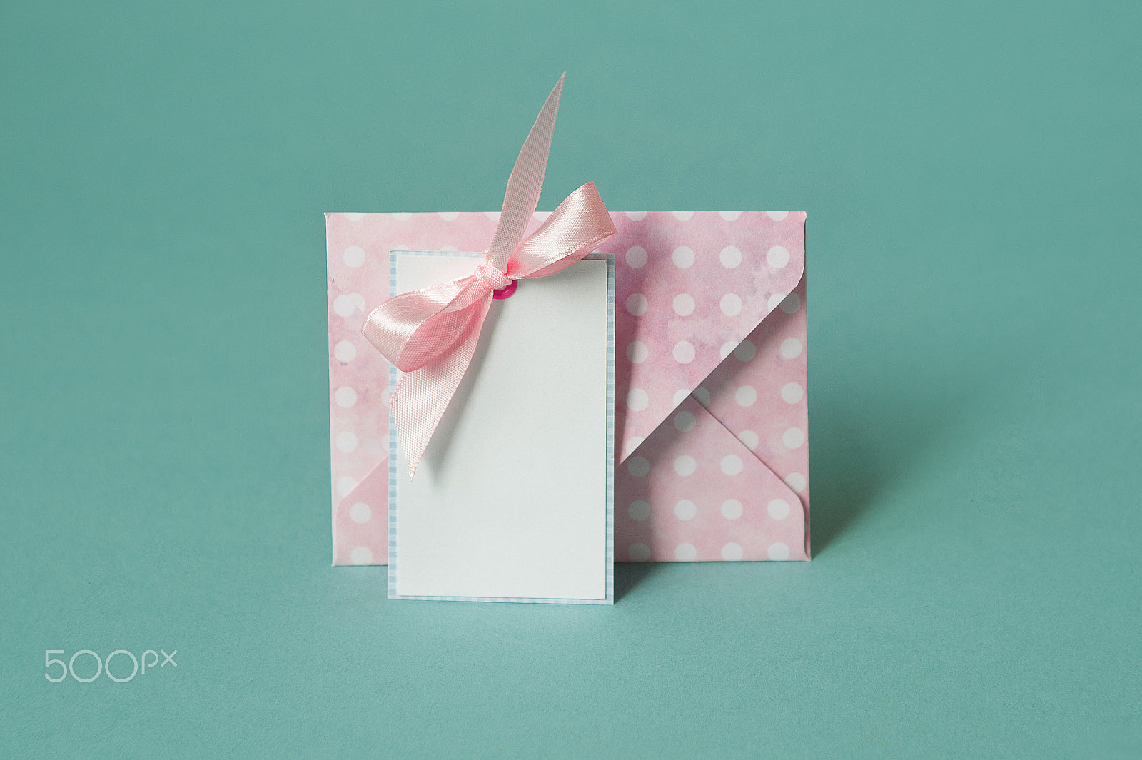 Nikon D700 sample photo. Blank white paper card with with a pink bow under envelop on a turquoise background photography