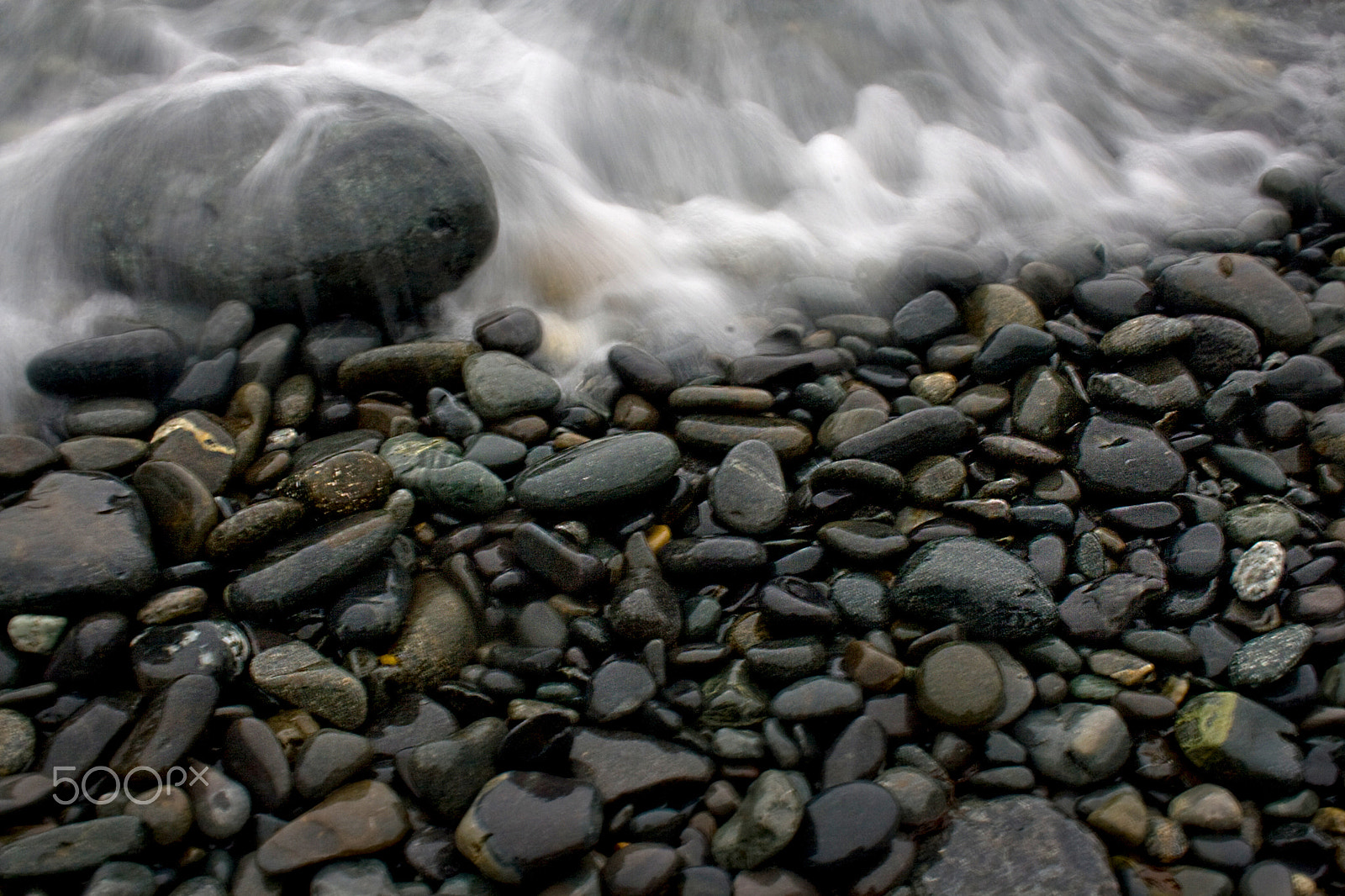 Canon EOS 400D (EOS Digital Rebel XTi / EOS Kiss Digital X) sample photo. Smooth beach stones with wave at ocean photography