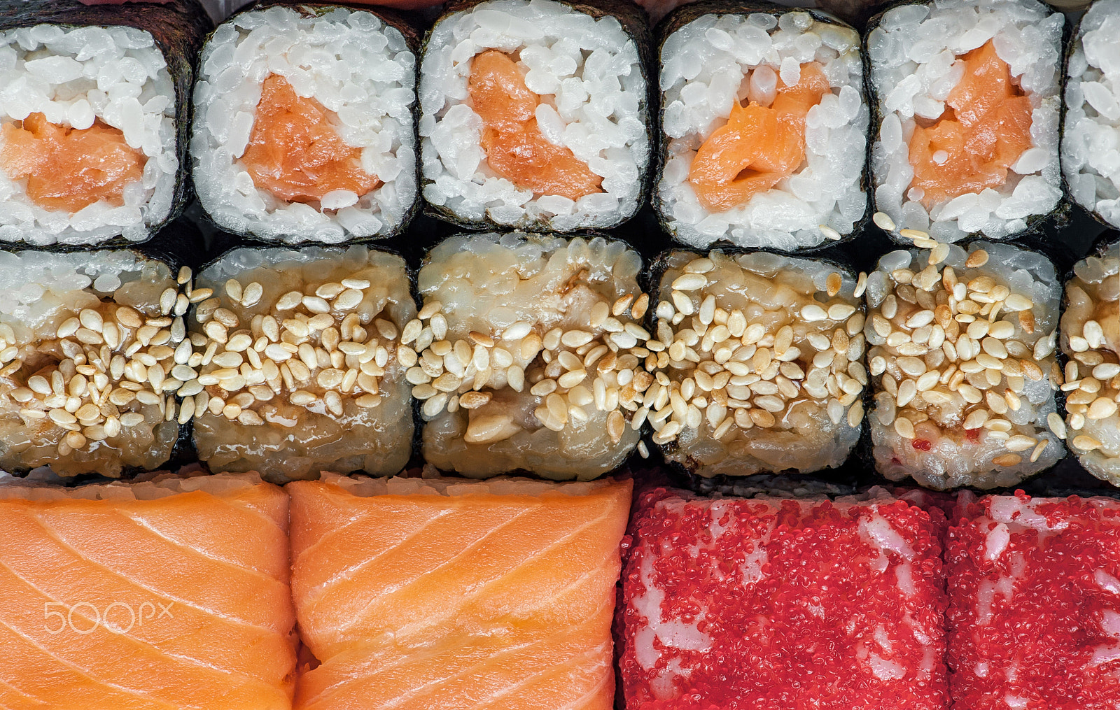 Nikon D700 sample photo. Multicolored rolls and sushi rice, caviar and salmon, are on the table in the background photography