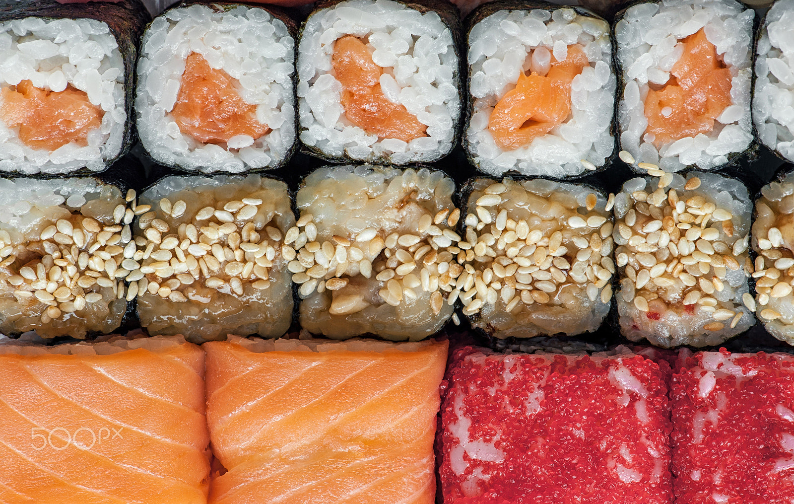 Nikon AF-S Micro-Nikkor 105mm F2.8G IF-ED VR sample photo. Multicolored rolls and sushi rice, caviar and salmon, are on the table in the background photography