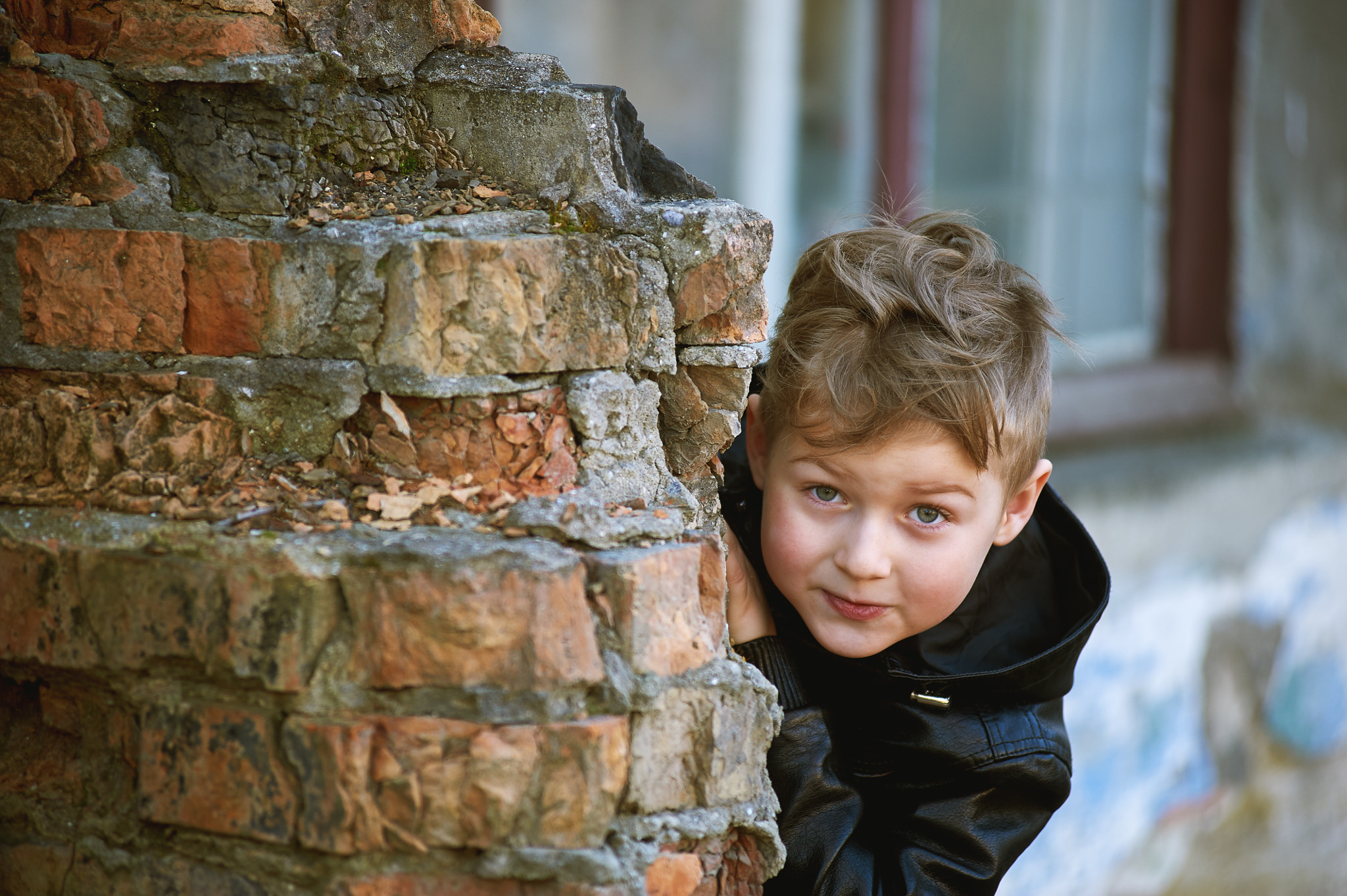 Nikon AF Zoom-Nikkor 80-200mm f/2.8D ED sample photo. A boy looks out from behind a corner . kids games photography