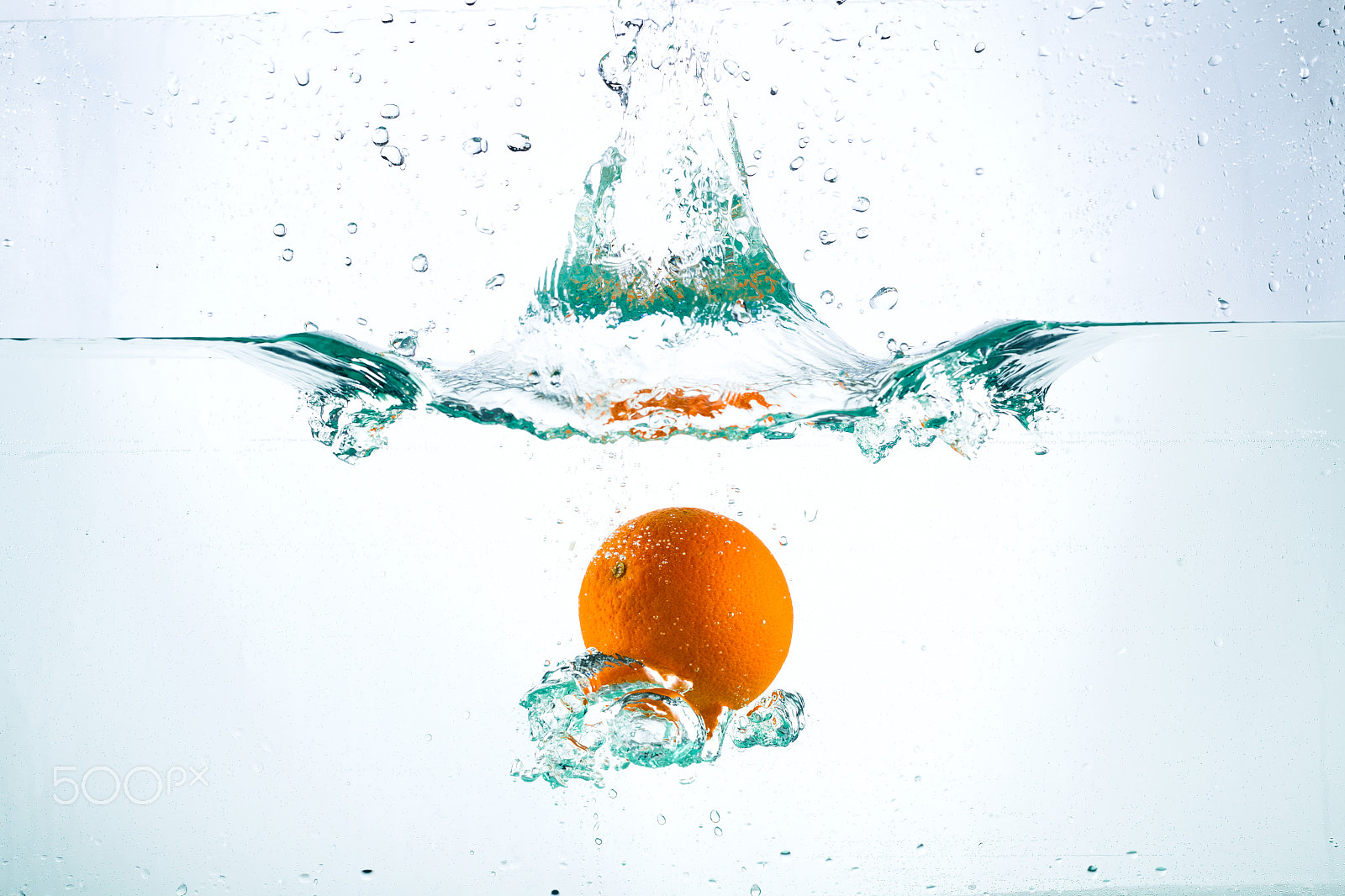 Canon EOS-1D Mark IV sample photo. Orange in streams of water on a white background photography