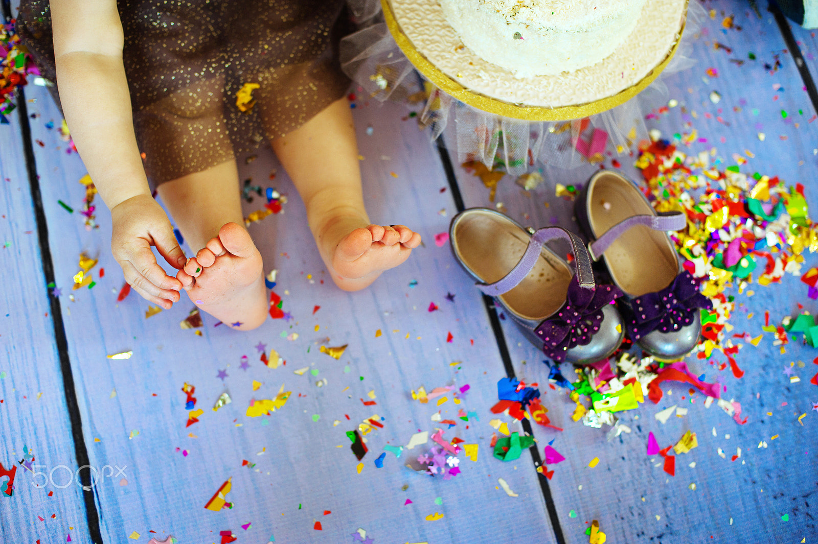 Nikon D700 + Nikon AF Nikkor 50mm F1.4D sample photo. Kid barefooted legs in against the confetti and garlands - selective focus, copy space photography
