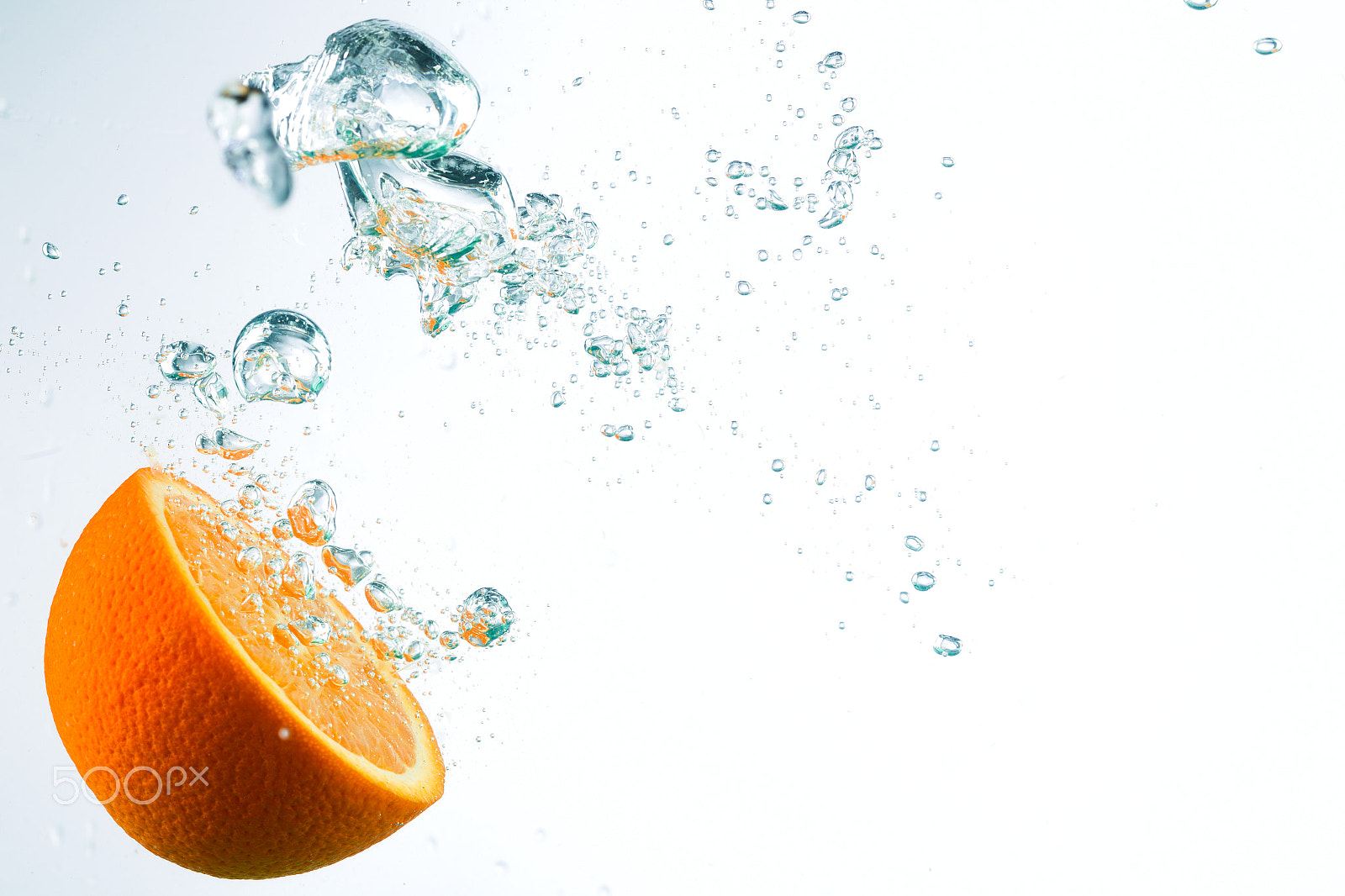 Canon EF 100mm F2.8L Macro IS USM sample photo. Orange in streams of water on a white background photography