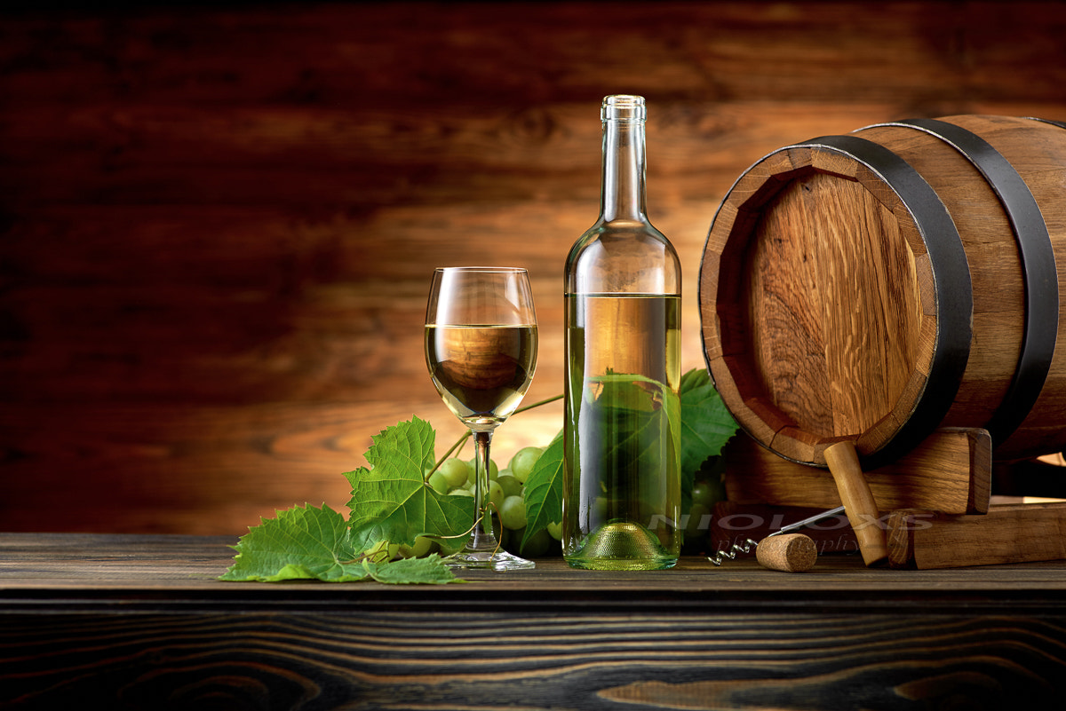 Wine bottle and glasses with wooden barrel on the table