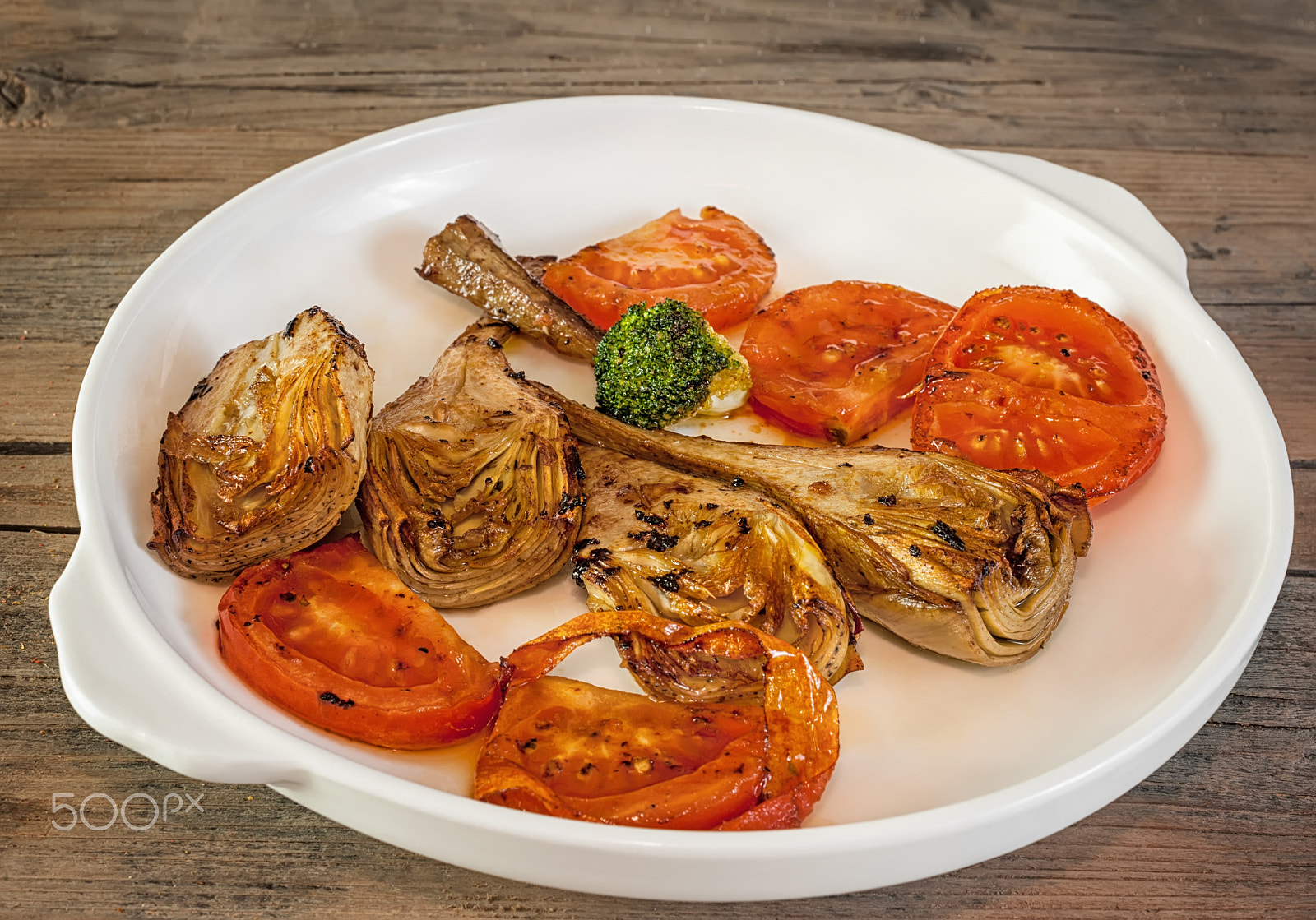 Nikon D700 + Nikon AF-S Nikkor 50mm F1.4G sample photo. Artichoke halves grilled with slices of ripe red tomatoes on a white plate and wooden background photography
