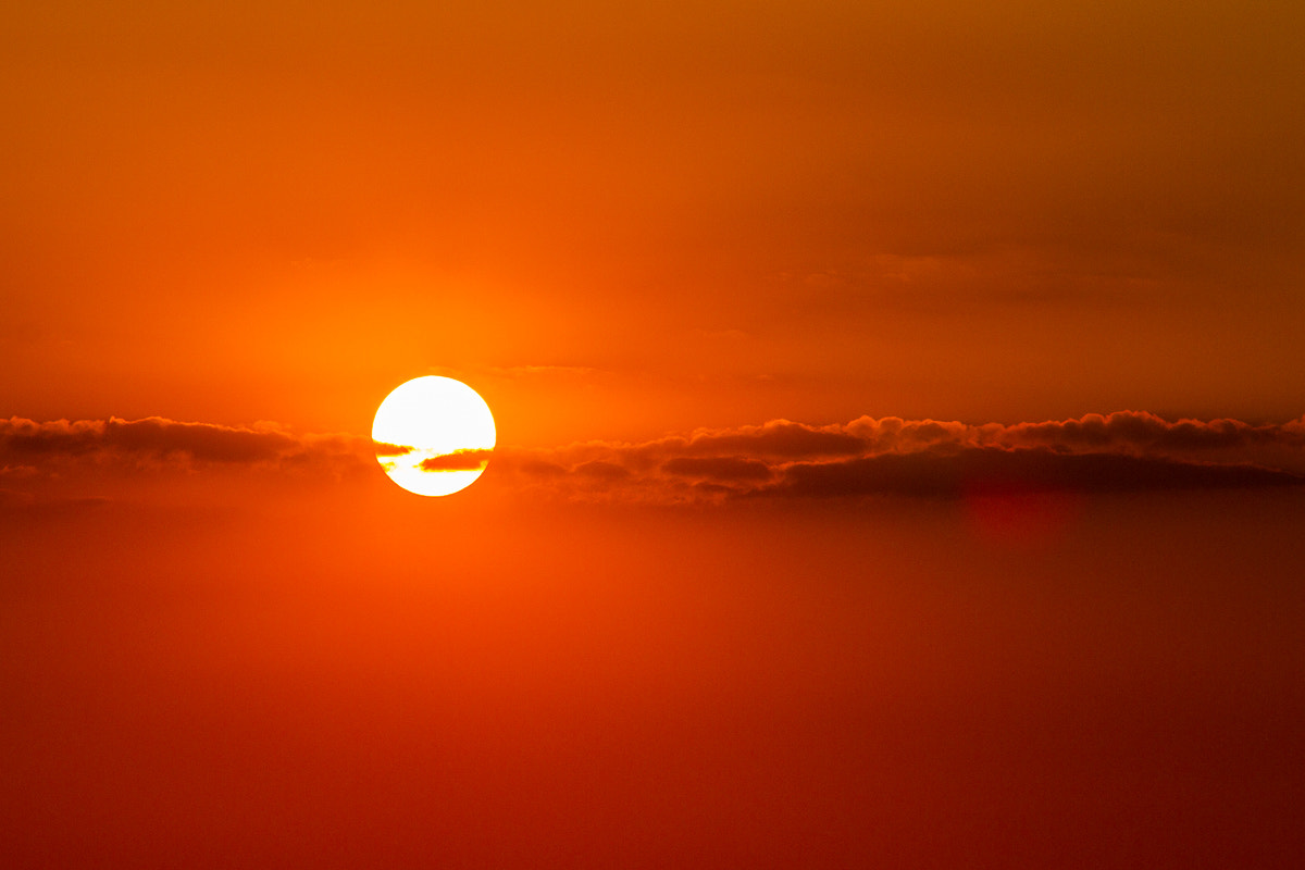 Canon EOS 7D sample photo. Sun setting behind thin cloud line photography