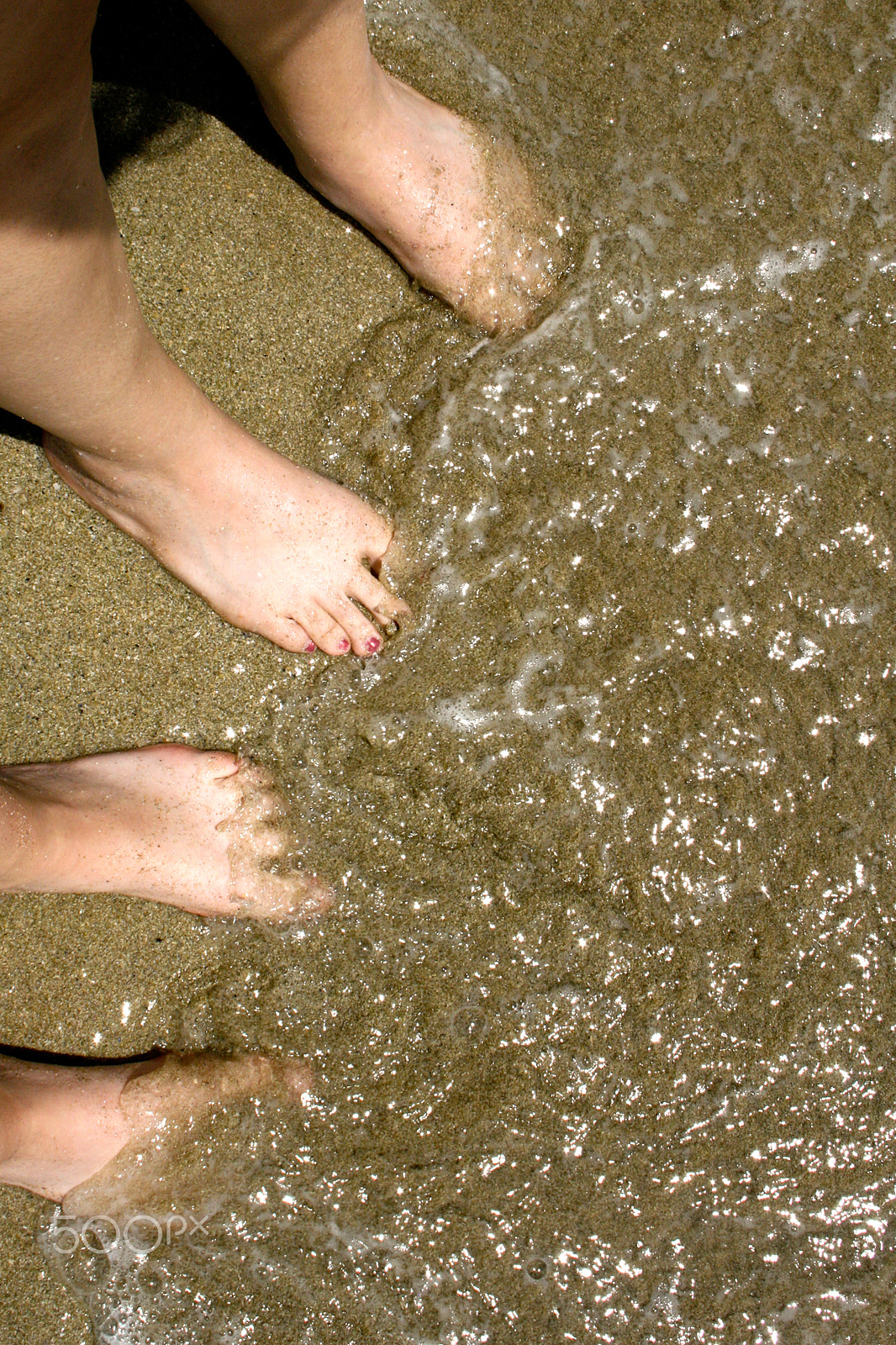 Canon EOS 400D (EOS Digital Rebel XTi / EOS Kiss Digital X) sample photo. Feet of two girls in sand at beach with water photography