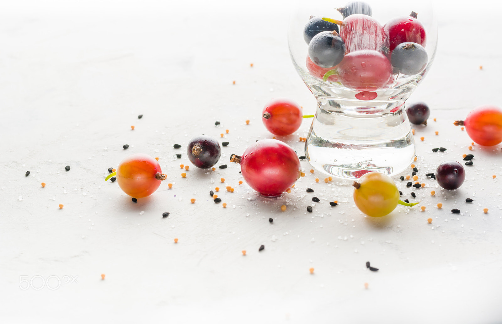 Nikon D7100 + Nikon AF-S Nikkor 50mm F1.8G sample photo. Gooseberries and black currants on a white background in a transparent glass. photography