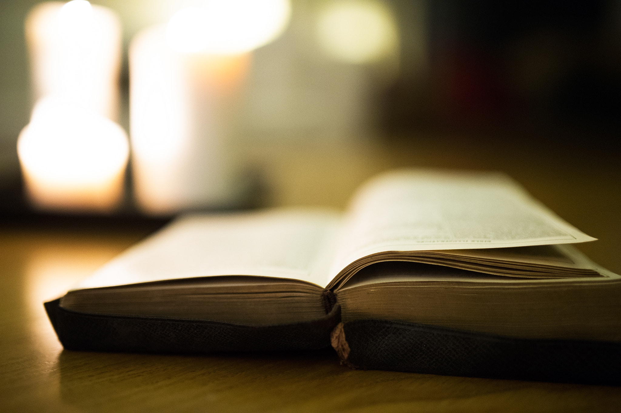 Nikon D4S + Sigma 35mm F1.4 DG HSM Art sample photo. Bible laid on wooden floor, burning candles in the background photography