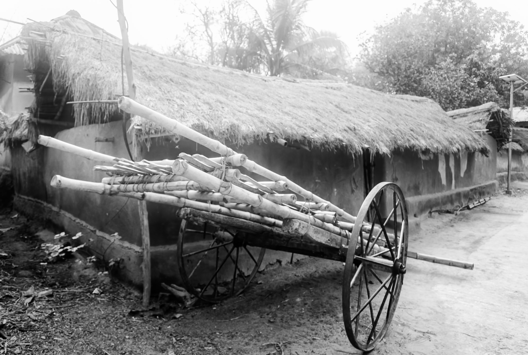 Nikon D7200 + Nikon AF-S DX Nikkor 18-55mm F3.5-5.6G VR sample photo. A bamboo made hand drawn cart in front of a mud house of a tribal village with copy space photography