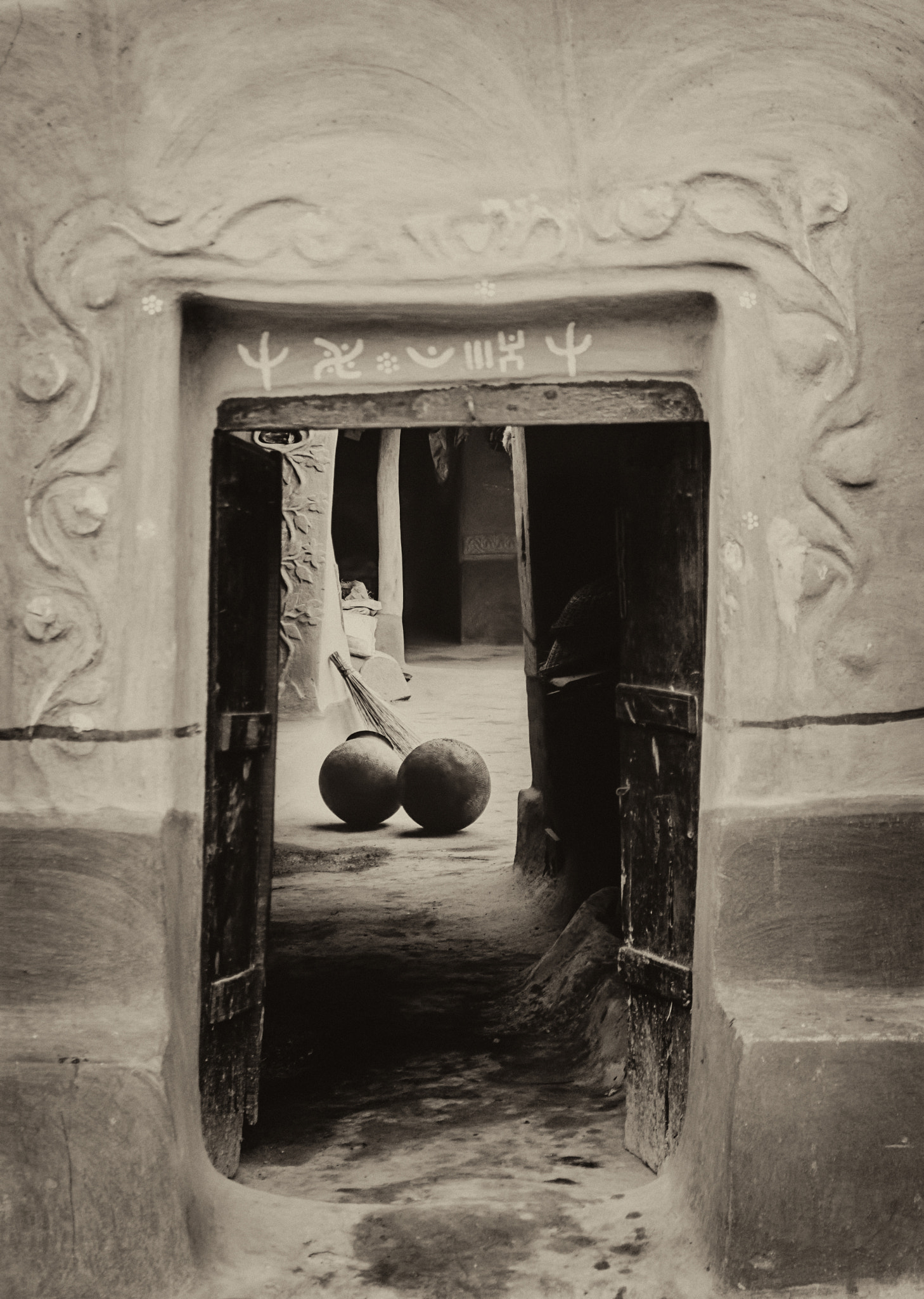 Nikon D7200 + Nikon AF-S DX Nikkor 18-55mm F3.5-5.6G VR sample photo. A santhal tribe village house, decorated doorway, two blackened pitchers, with copy space photography