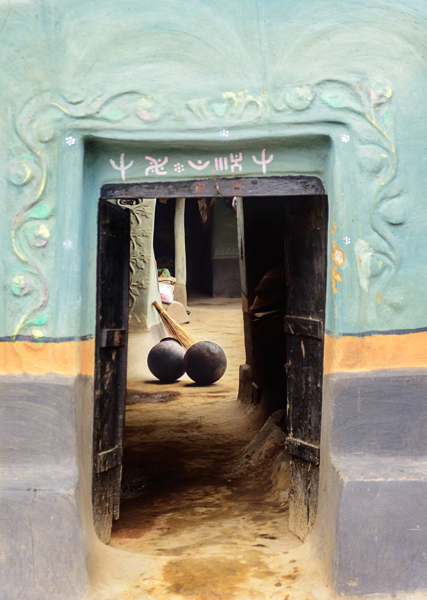 Nikon D7200 sample photo. A santhal tribe village house, decorated doorway, two blackened pitchers, with copy space photography