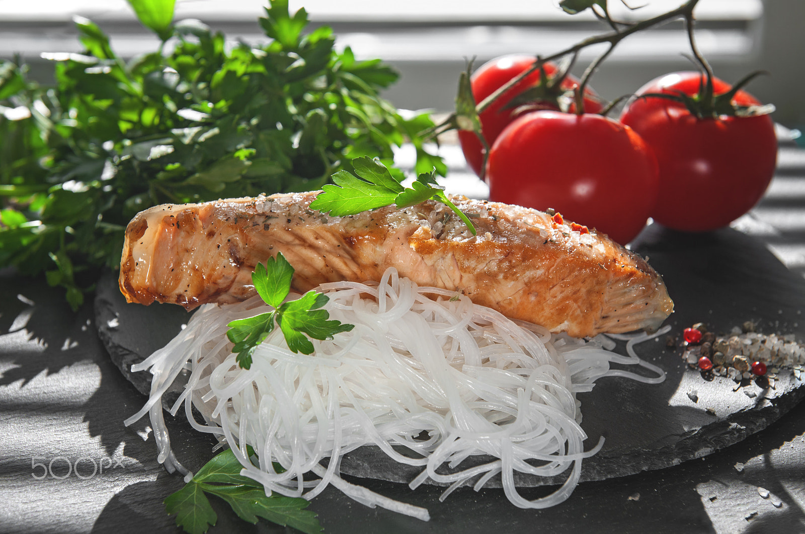 Nikon AF-S Nikkor 24-70mm F2.8G ED sample photo. Cellophane with pieces of roasted salmon with tomatoes, onion and parsley on the board of black... photography