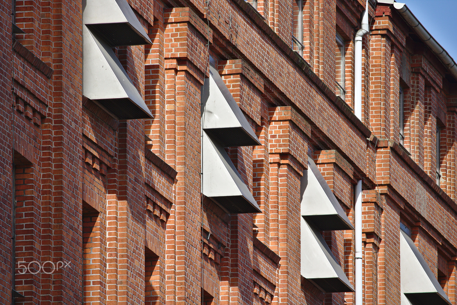 Canon EOS 750D (EOS Rebel T6i / EOS Kiss X8i) + Canon EF-S 55-250mm F4-5.6 IS STM sample photo. Red brick wall with row of narrow windows and metal wall vents photography