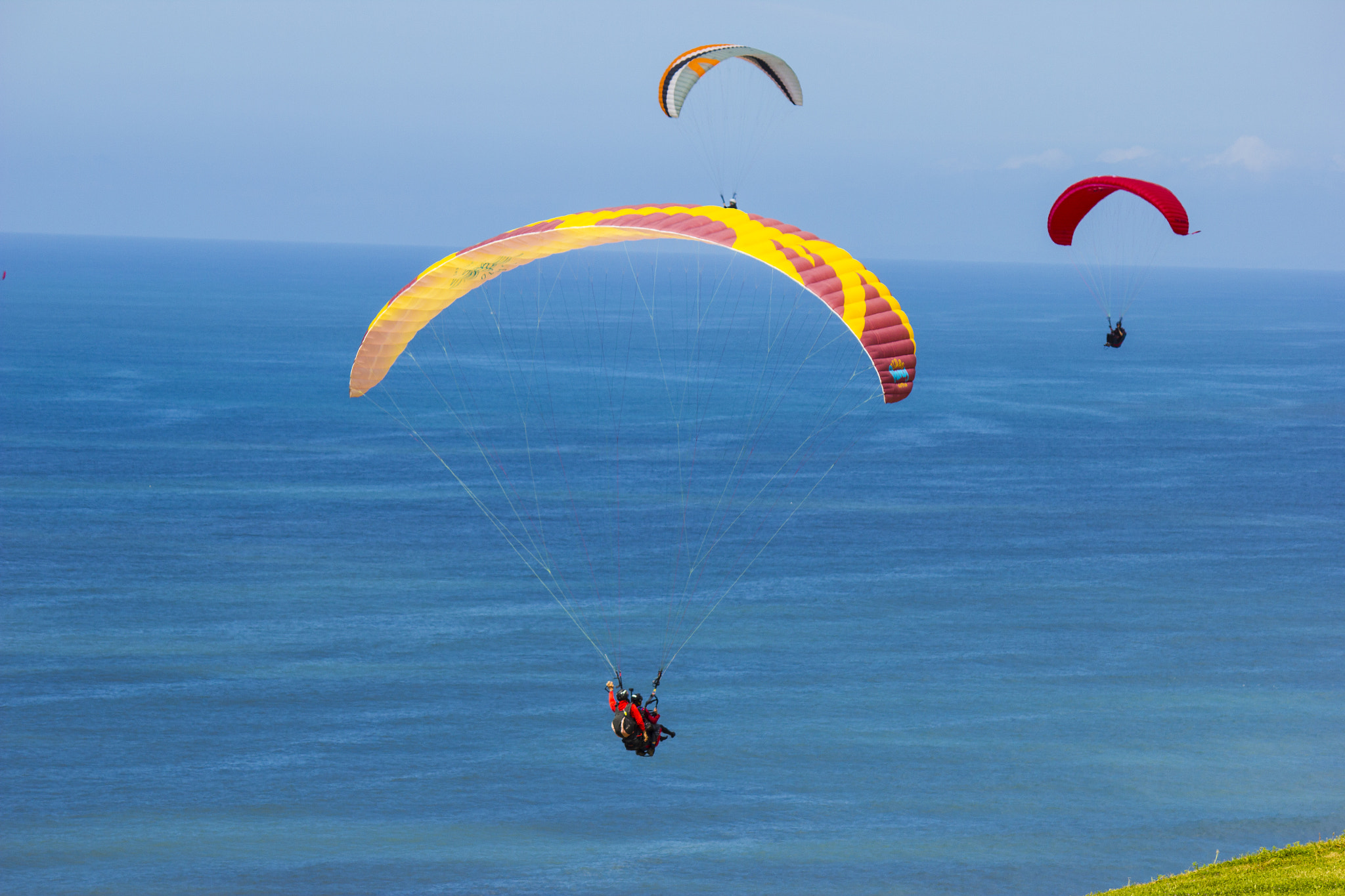 Canon EF-S 55-250mm F4-5.6 IS sample photo. Para-gliders flying together over the ocean photography